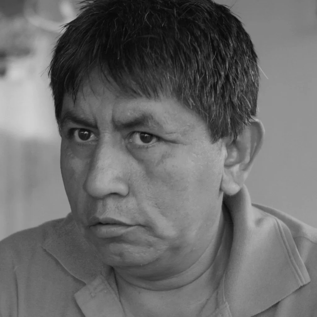 Black and white close-up photo of a man with short hair looking to his left.