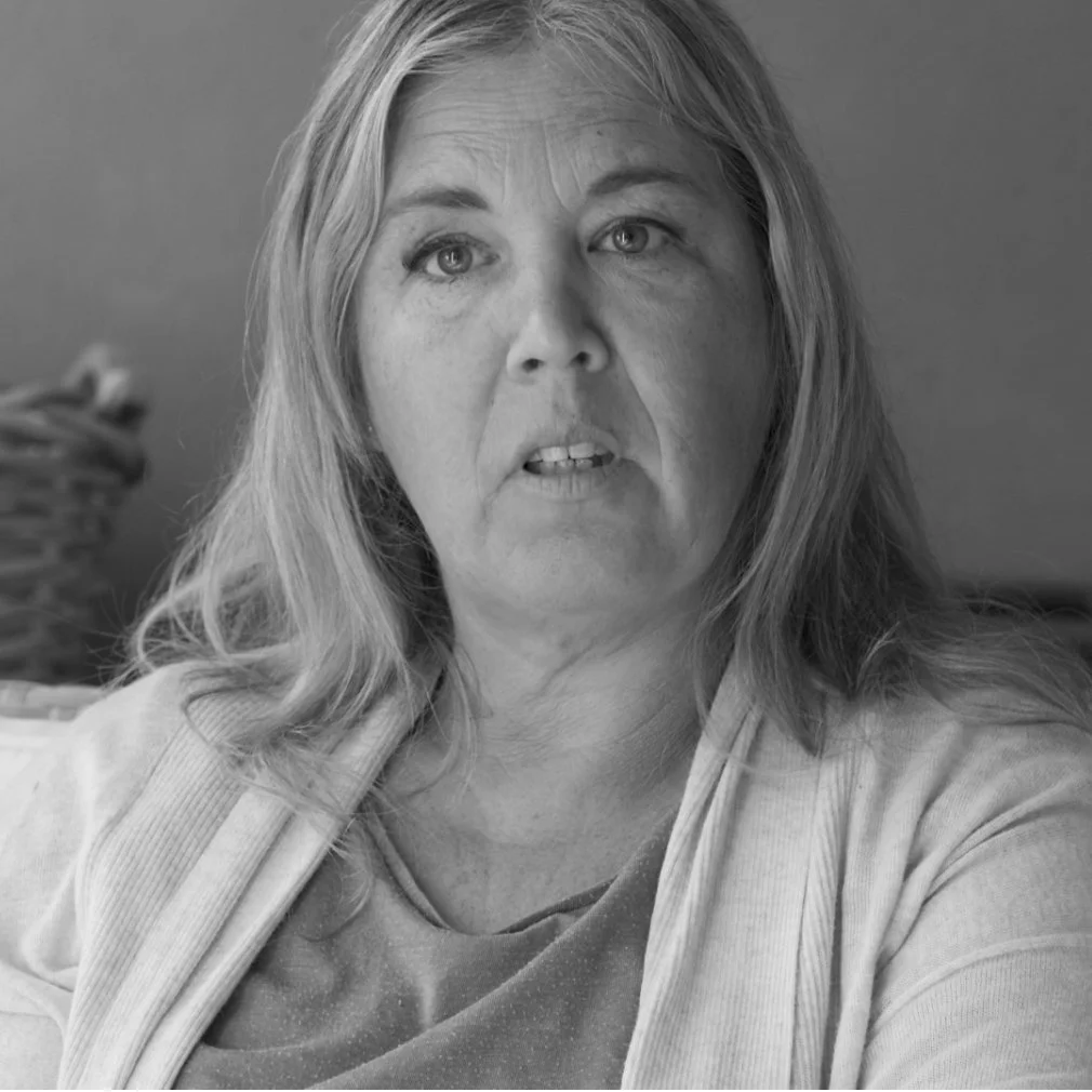 Black and white photo of a middle-aged woman with shoulder-length hair, looking slightly to the side, with a serious expression.