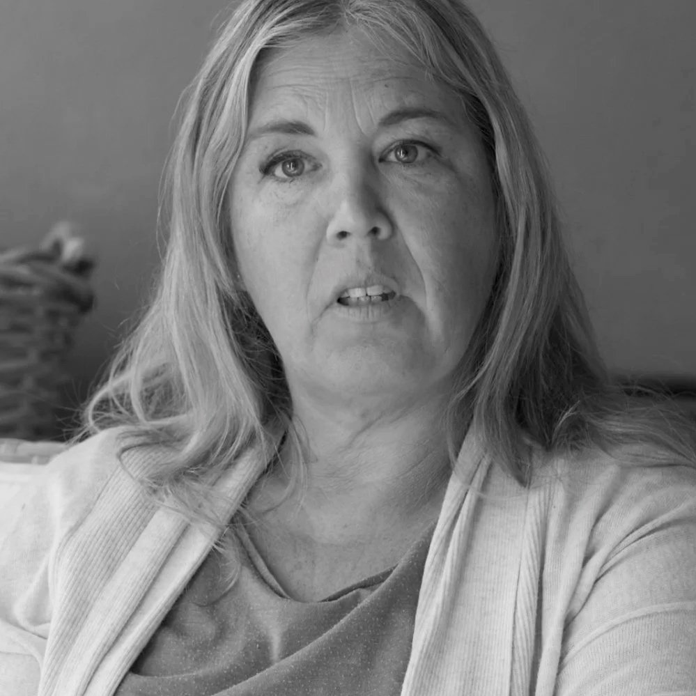 Black and white photo of a middle-aged woman with shoulder-length hair, looking slightly to the side, with a serious expression.