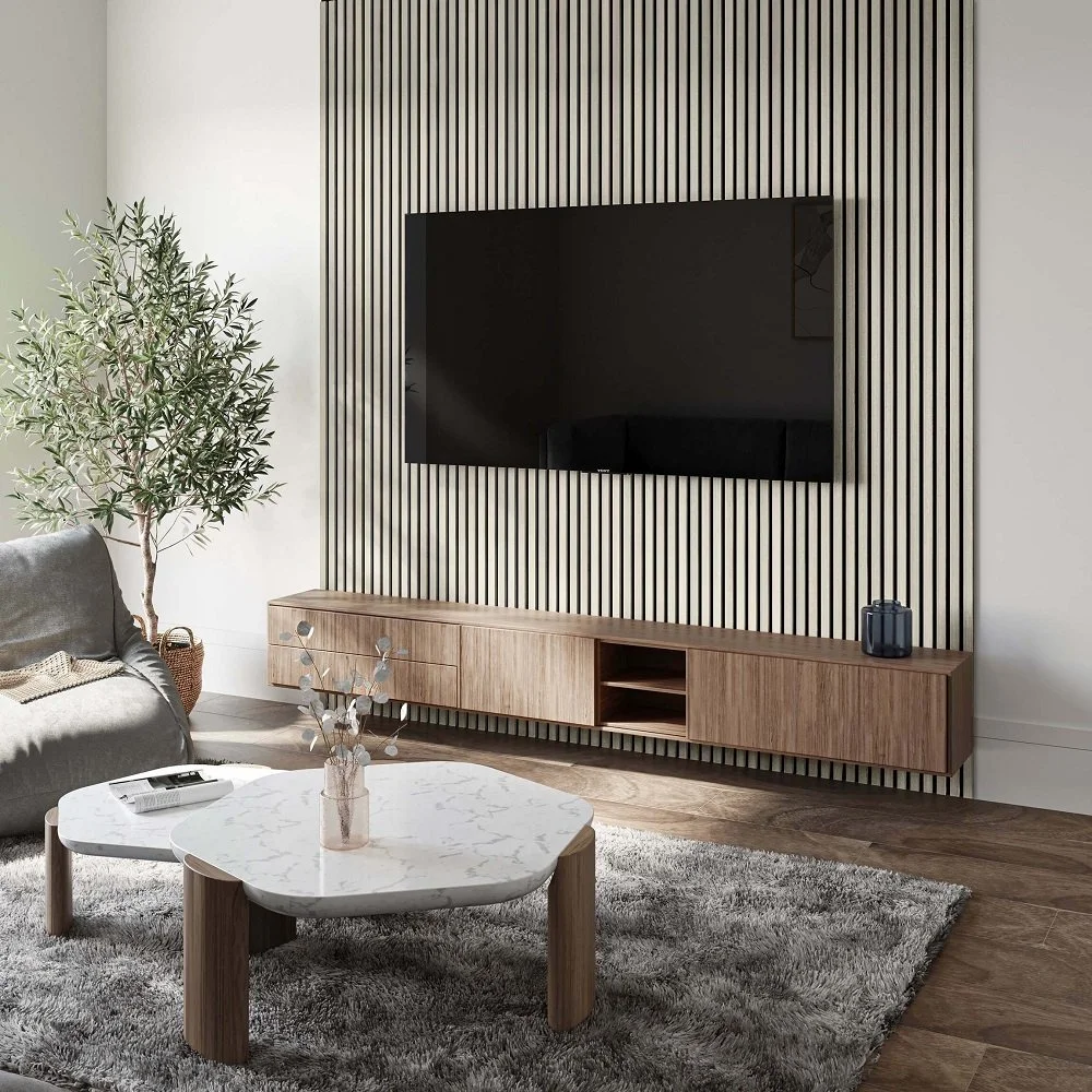 Modern living room with a wooden TV stand, a wall-mounted flat-screen TV, a large potted plant, a gray sofa, a white marble coffee table with wooden legs, a gray area rug, and minimal decor.