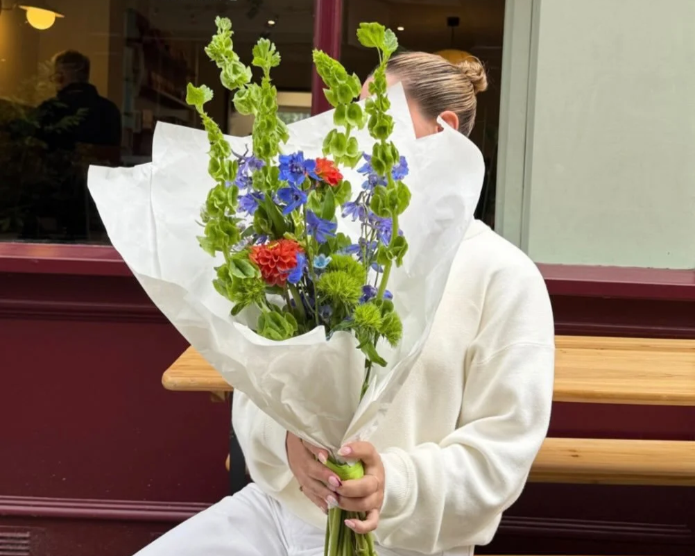 Model posed with a bouquet by Urban Bloom Flower Studio outside cafe