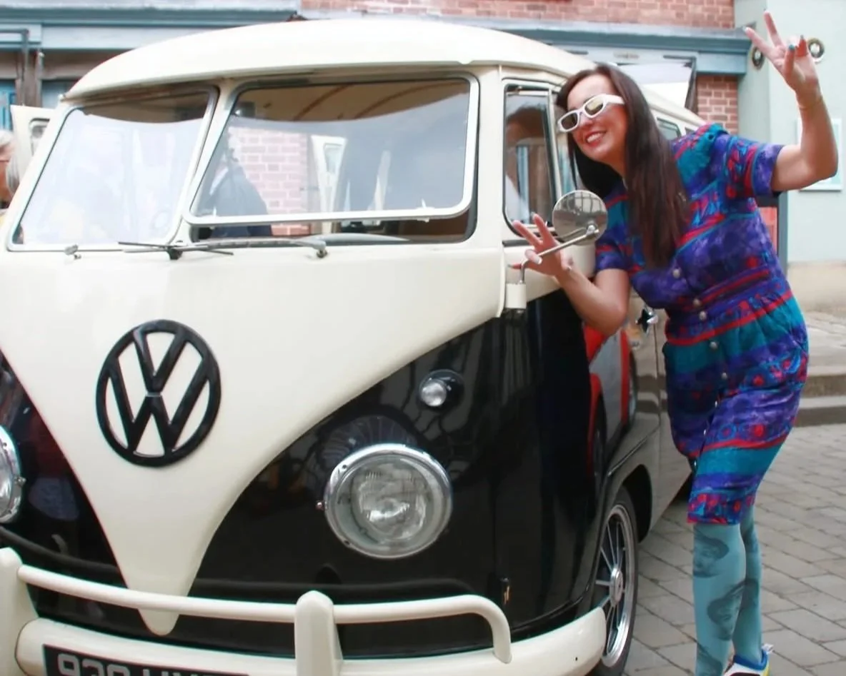 Woman posing outside VW camper van in Stockport market place