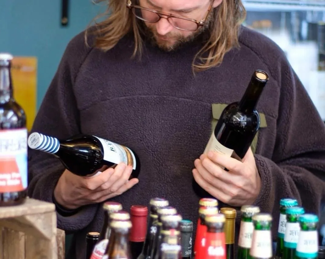 Wine Boy choosing bottles at the market stall in Stockport