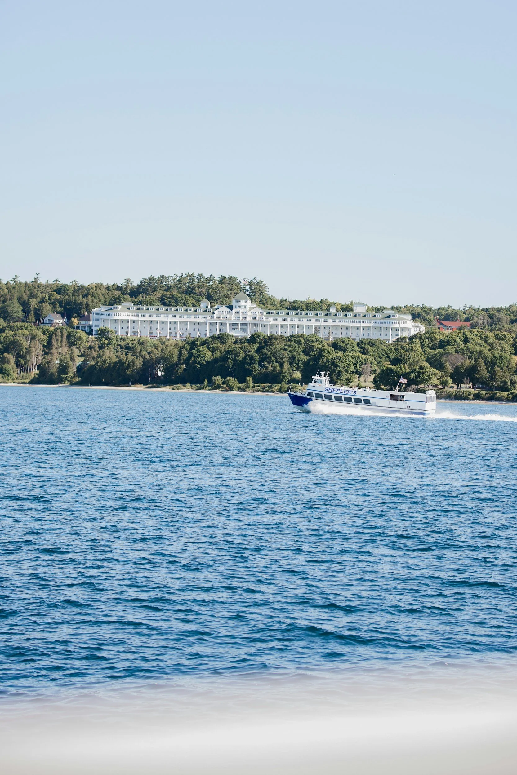 Ferry on the water in front of a white building