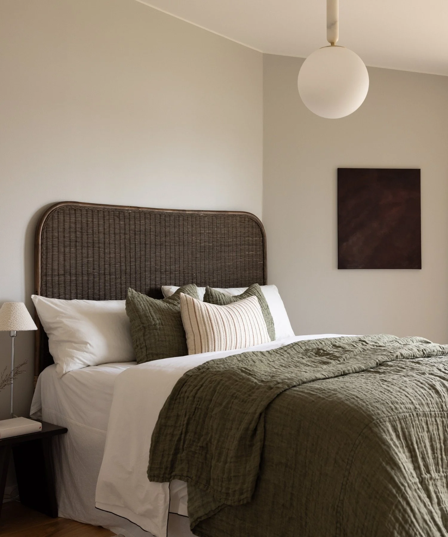 Sovrum inrett med mjuka textilier, naturliga material och mörkbruna, gröna och vinröda toner