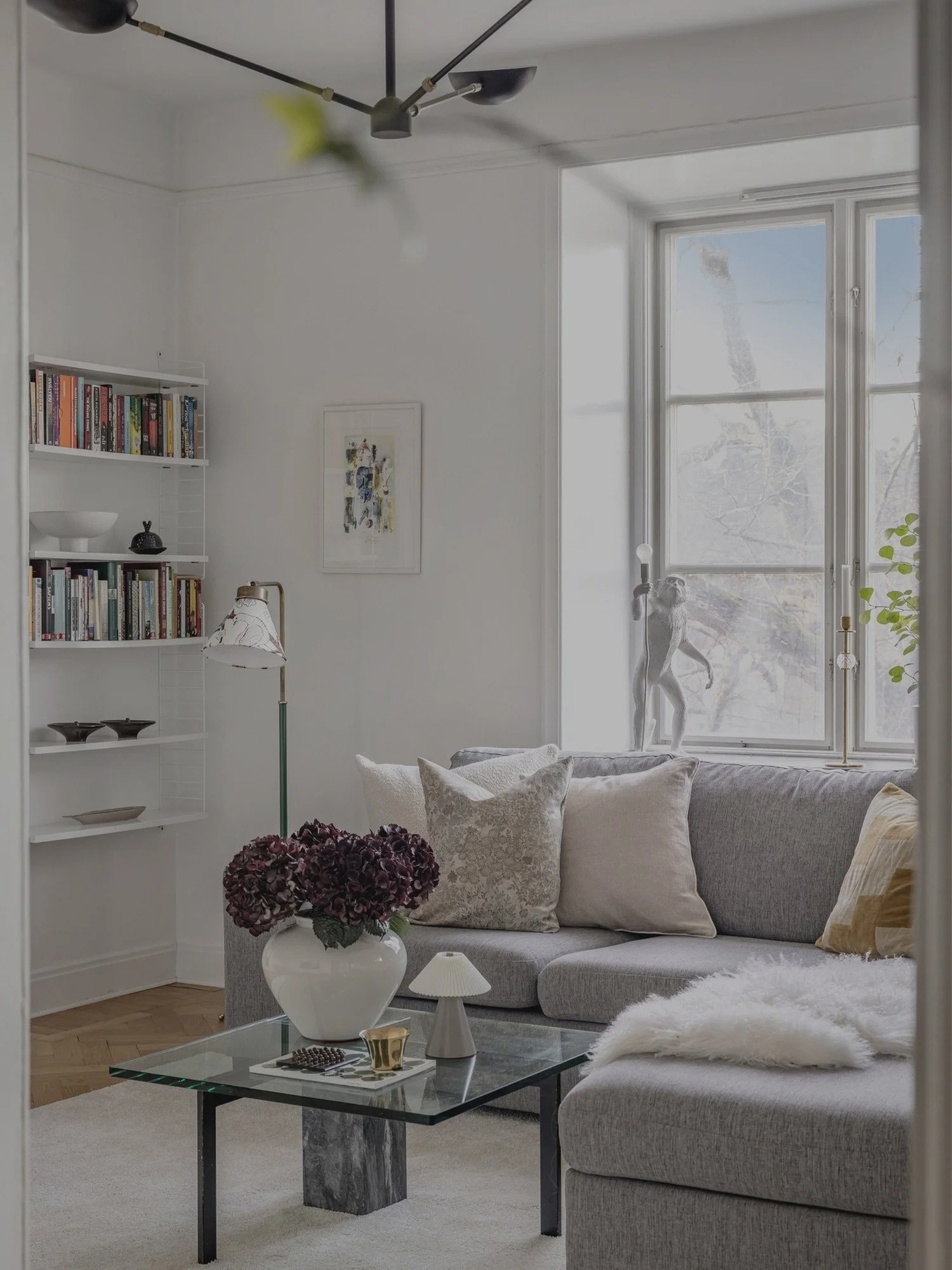 Inredning av skandinaviskt vardagsrum med moderna möbler, personlig dekor och belysning