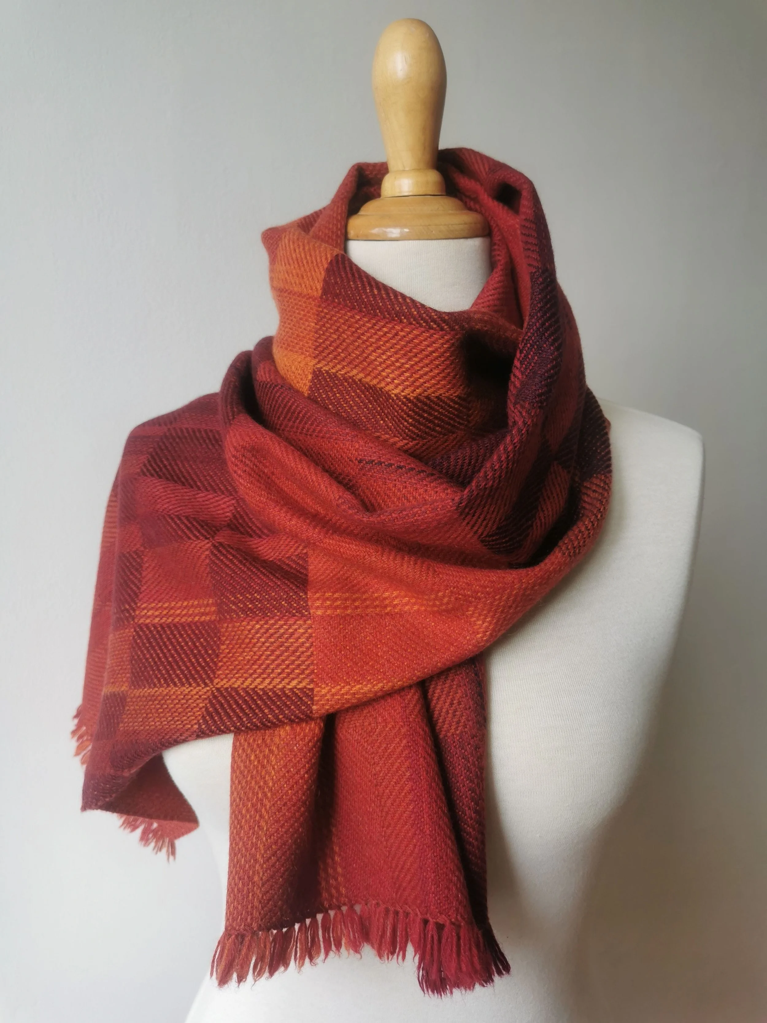 Foulard en tissu à carreaux bleu, noir, gris enroulé autour d'une poupée mannequin en bois