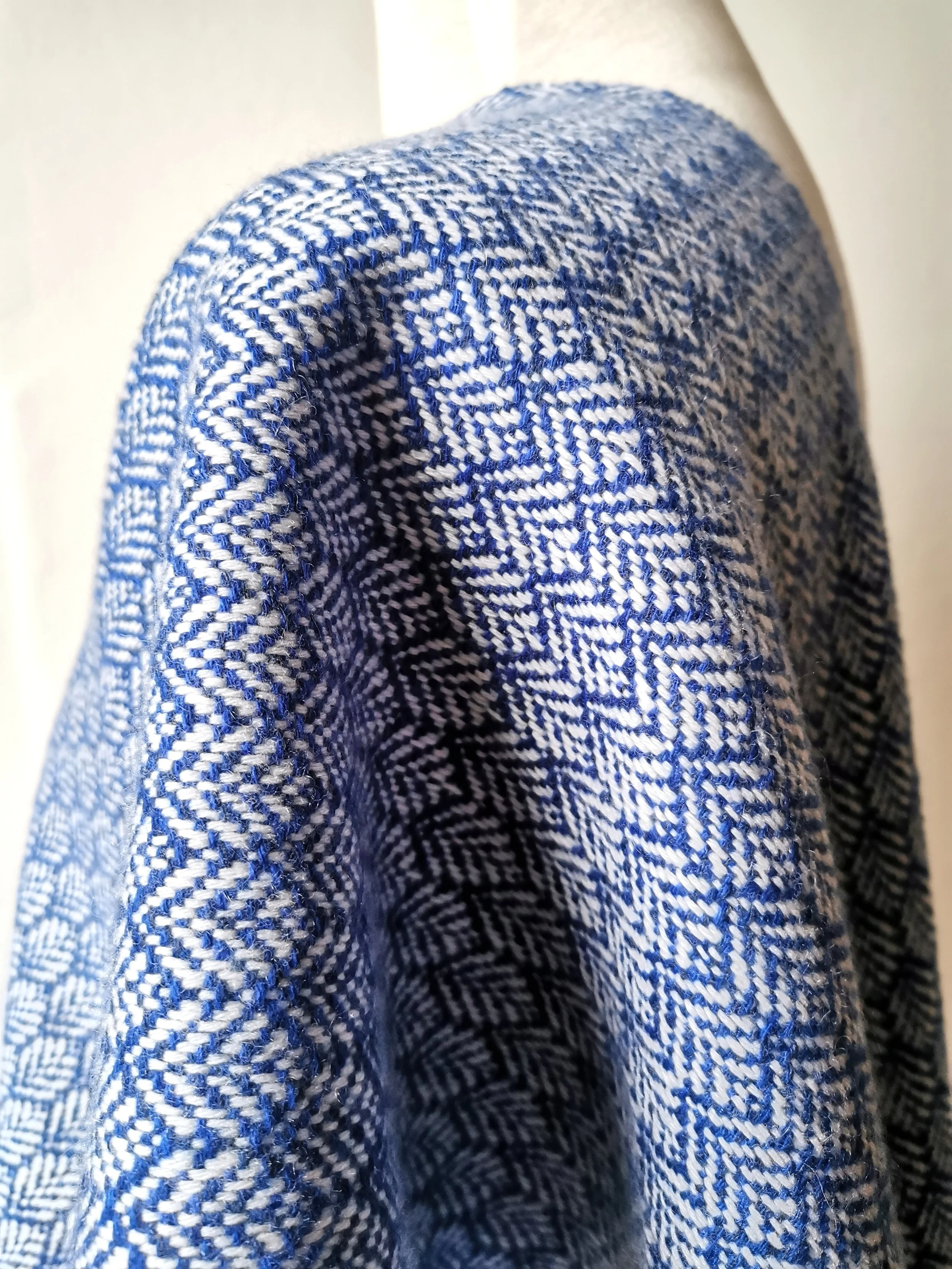Détail du motif géométrique tissé main de l'écharpe Rythme, cachemire bleu profond et écru