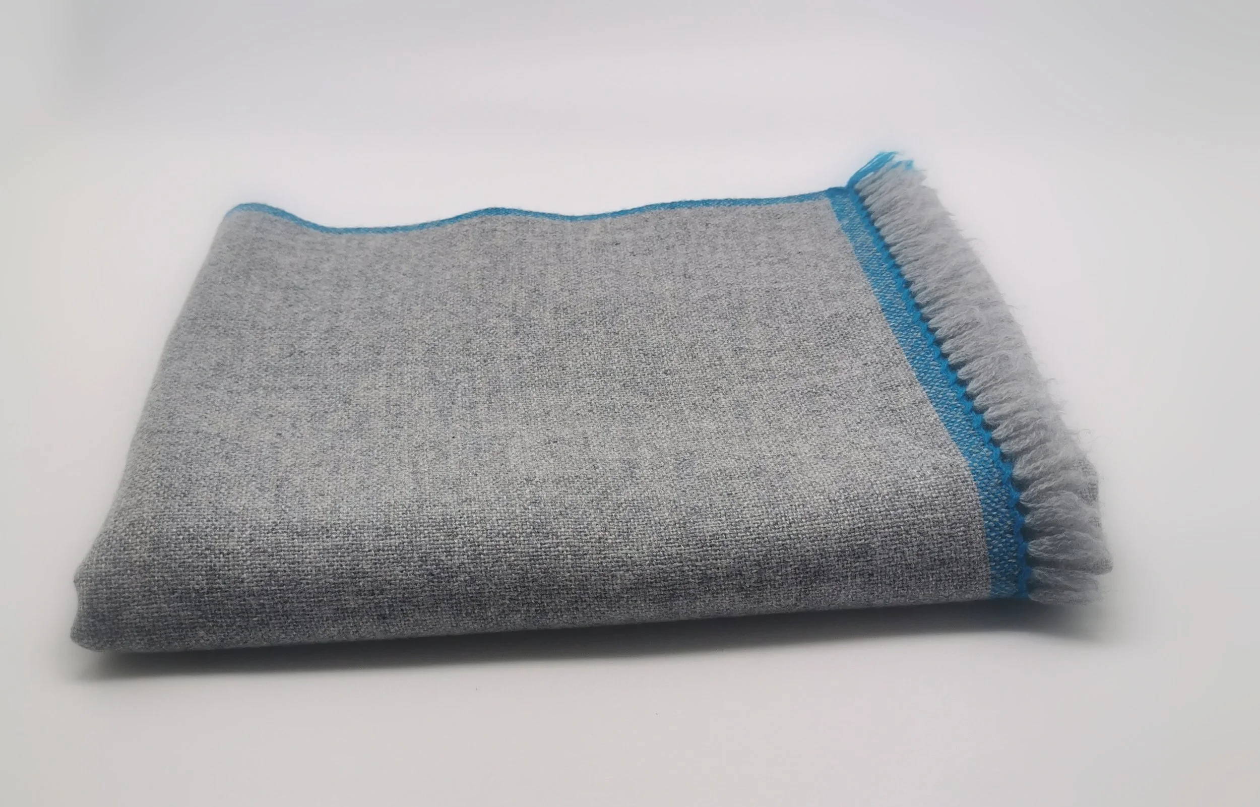 Détail du tissage et des franges de l'écharpe Épure, cachemire gris chiné, bordure bleu vif