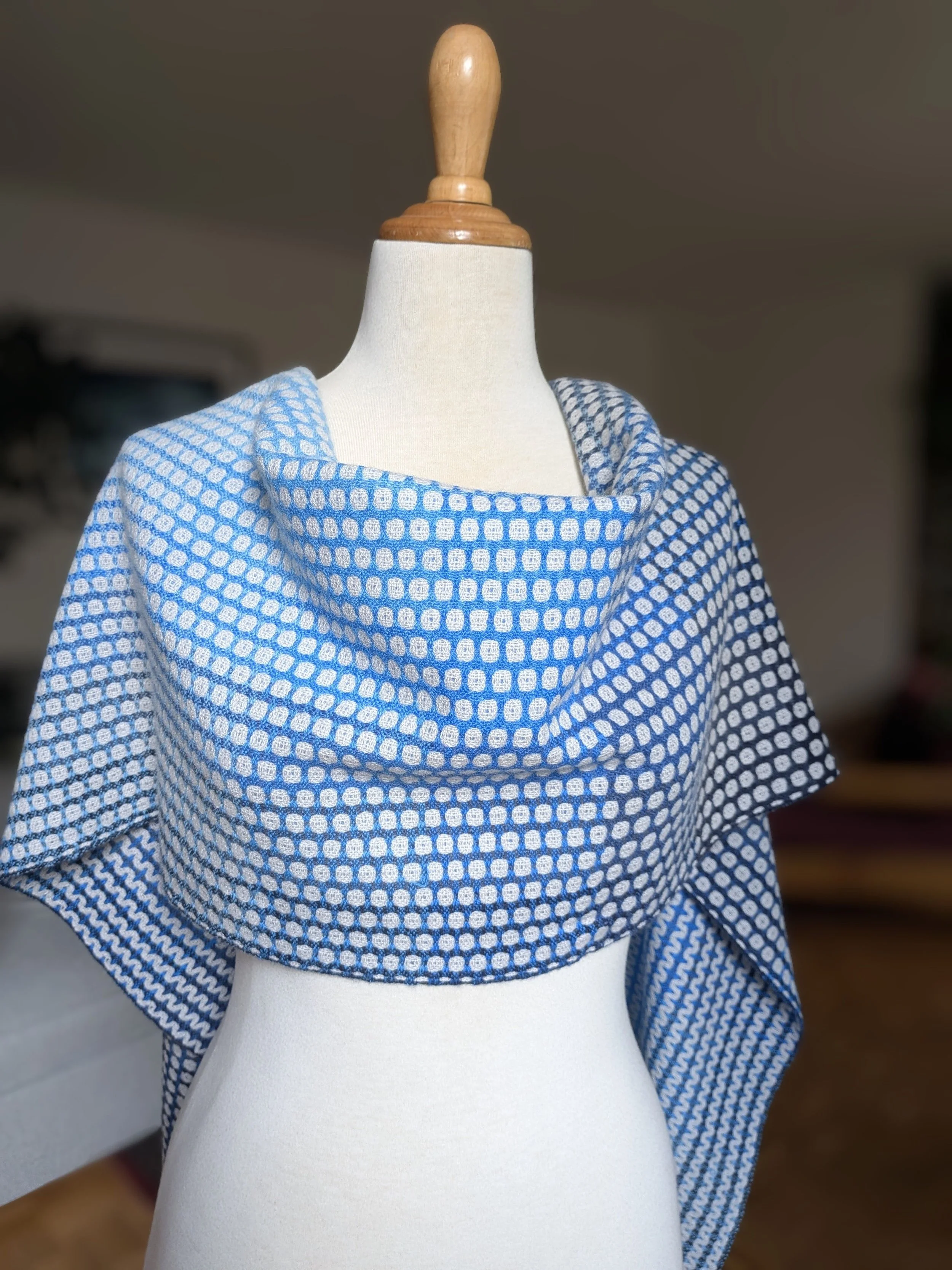 Écharpe Outrebleu en pur cachemire drapée en cowl autour du cou et des épaules d'un mannequin, face à petits ronds en dégradé de bleu