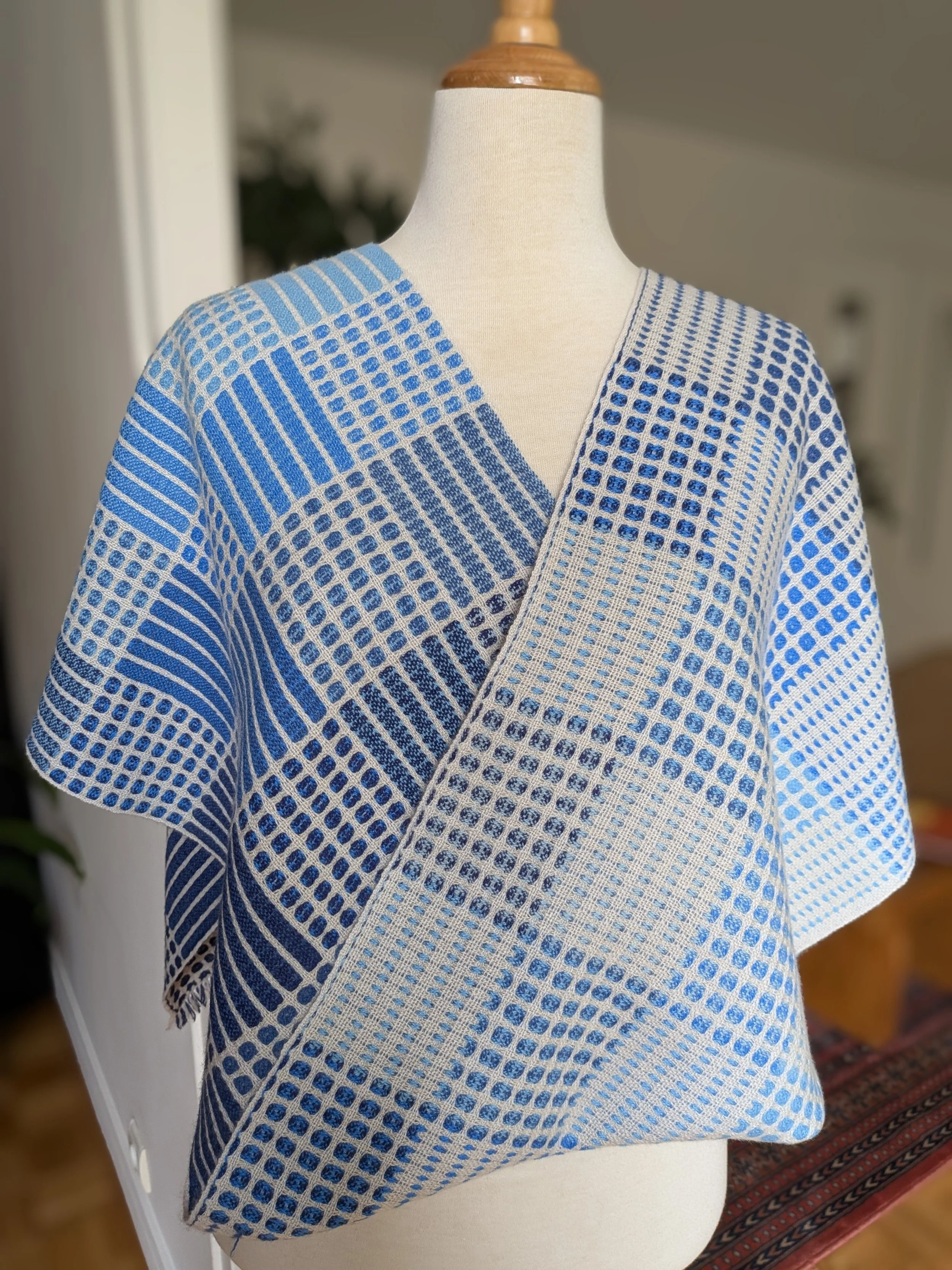 Écharpe Variation en bleu en cachemire drapée sur un mannequin, montrant ses deux faces côte à côte : l'une à dominante bleue, l'autre plus claire, à dominante écrue