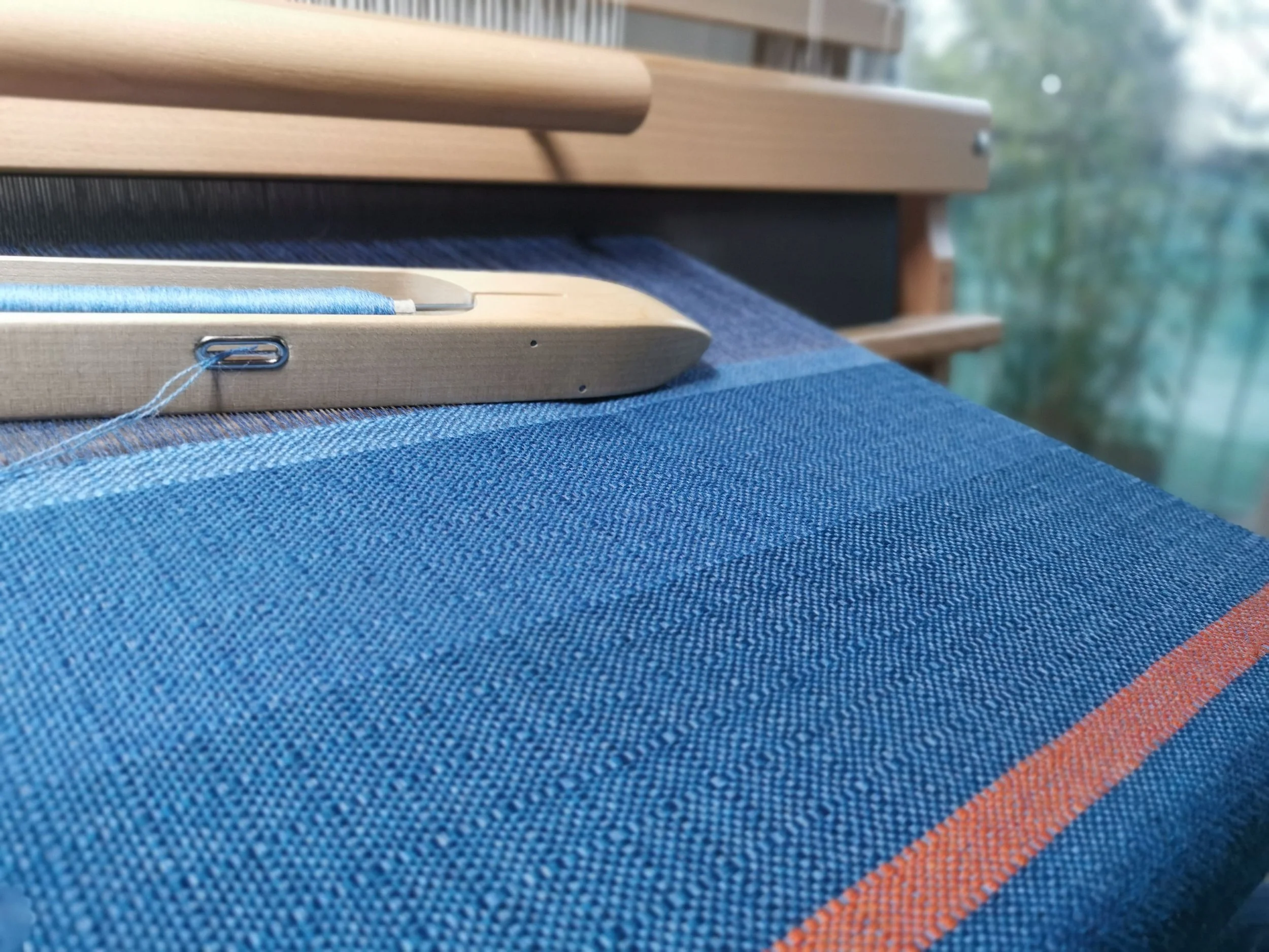 Écharpe Cobalt & Sienne en cours de tissage sur métier à bras, laine mérinos bleu et ligne sienne