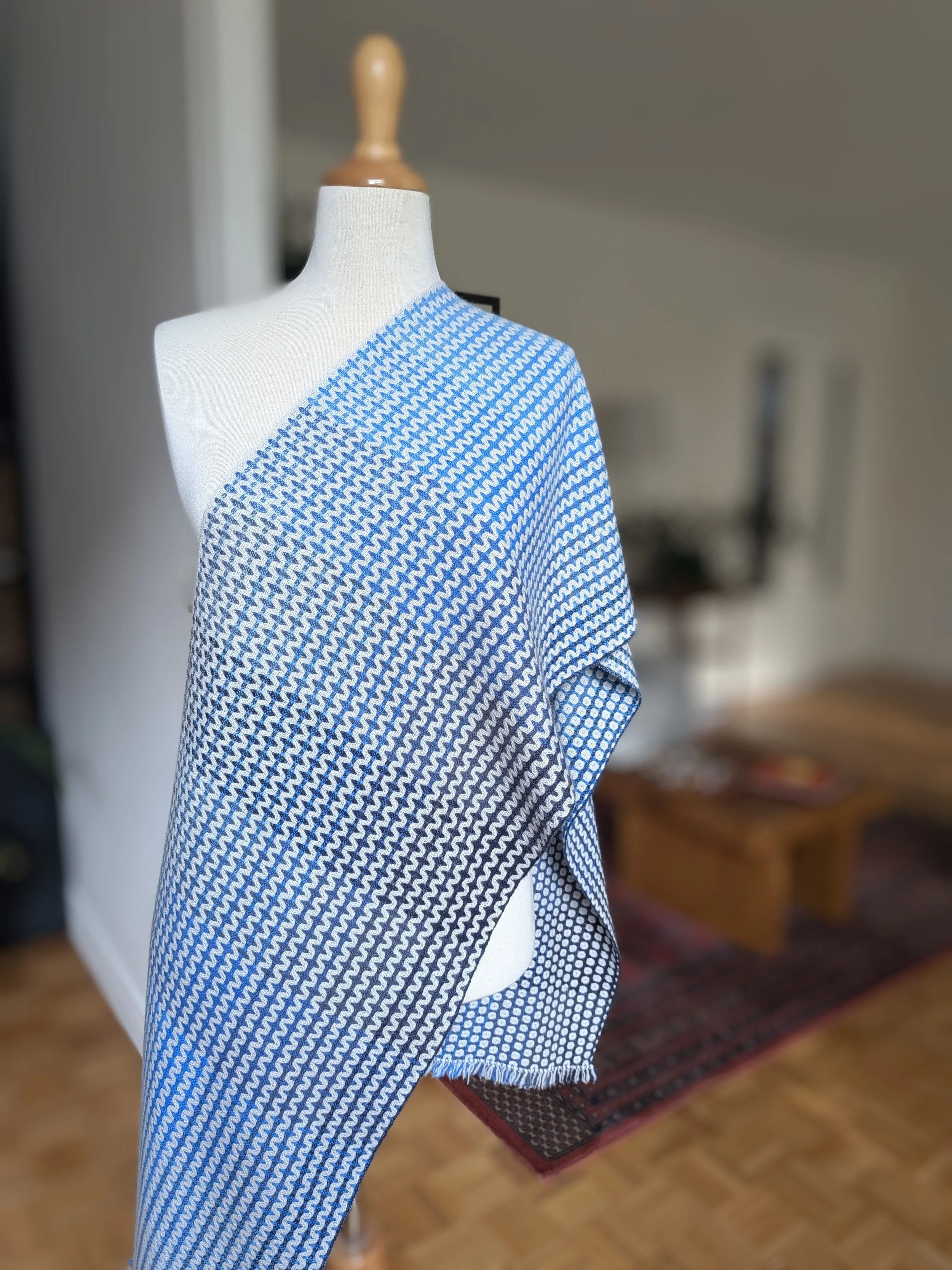 Écharpe Outrebleu en pur cachemire drapée en diagonale sur l'épaule d'un mannequin, face en zigzags en dégradé de bleu marine à bleu clair