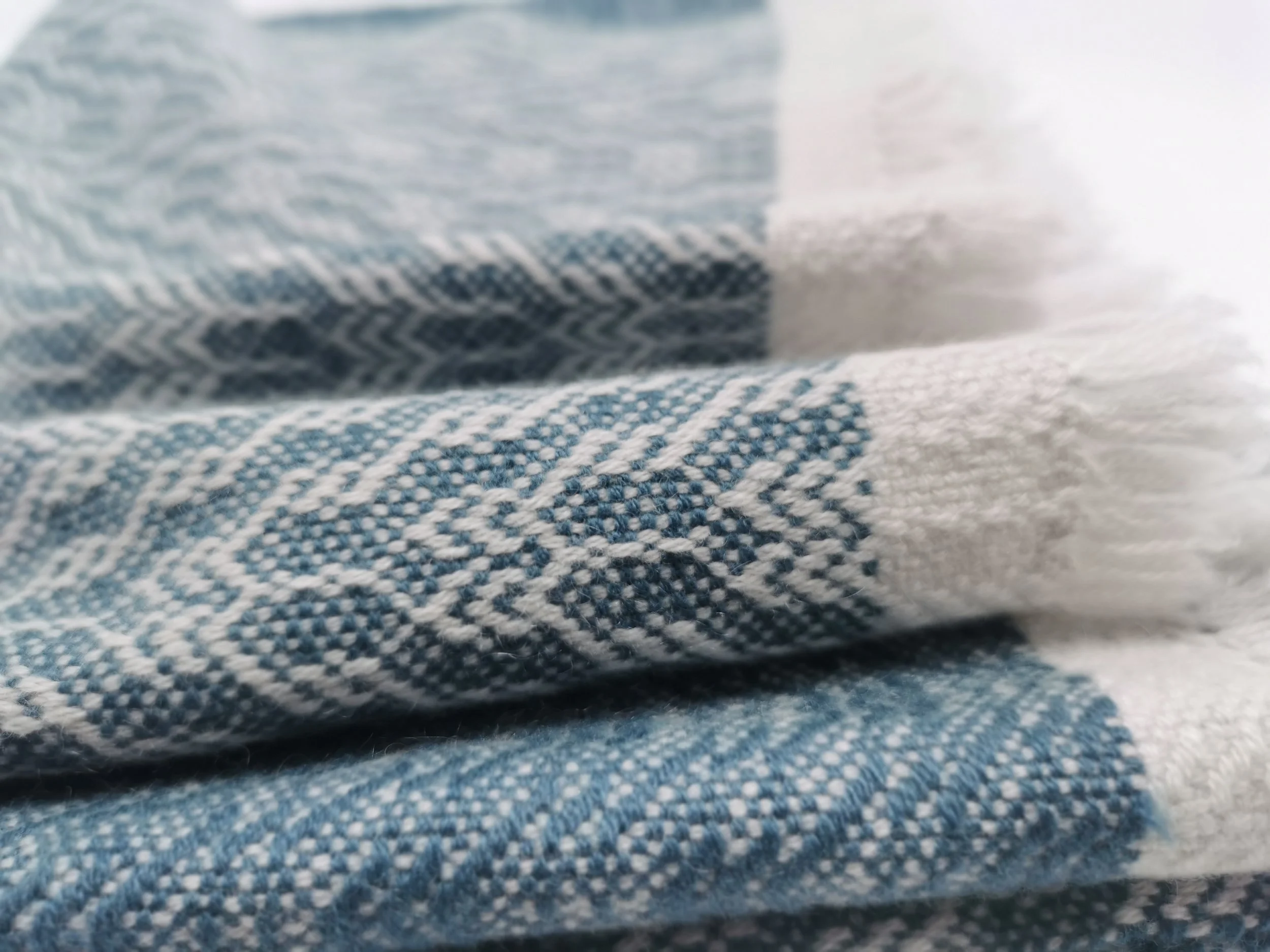 Zoom sur un tissu en coton à motifs bleus et blancs, avec une texture décontractée et des détails en maille.