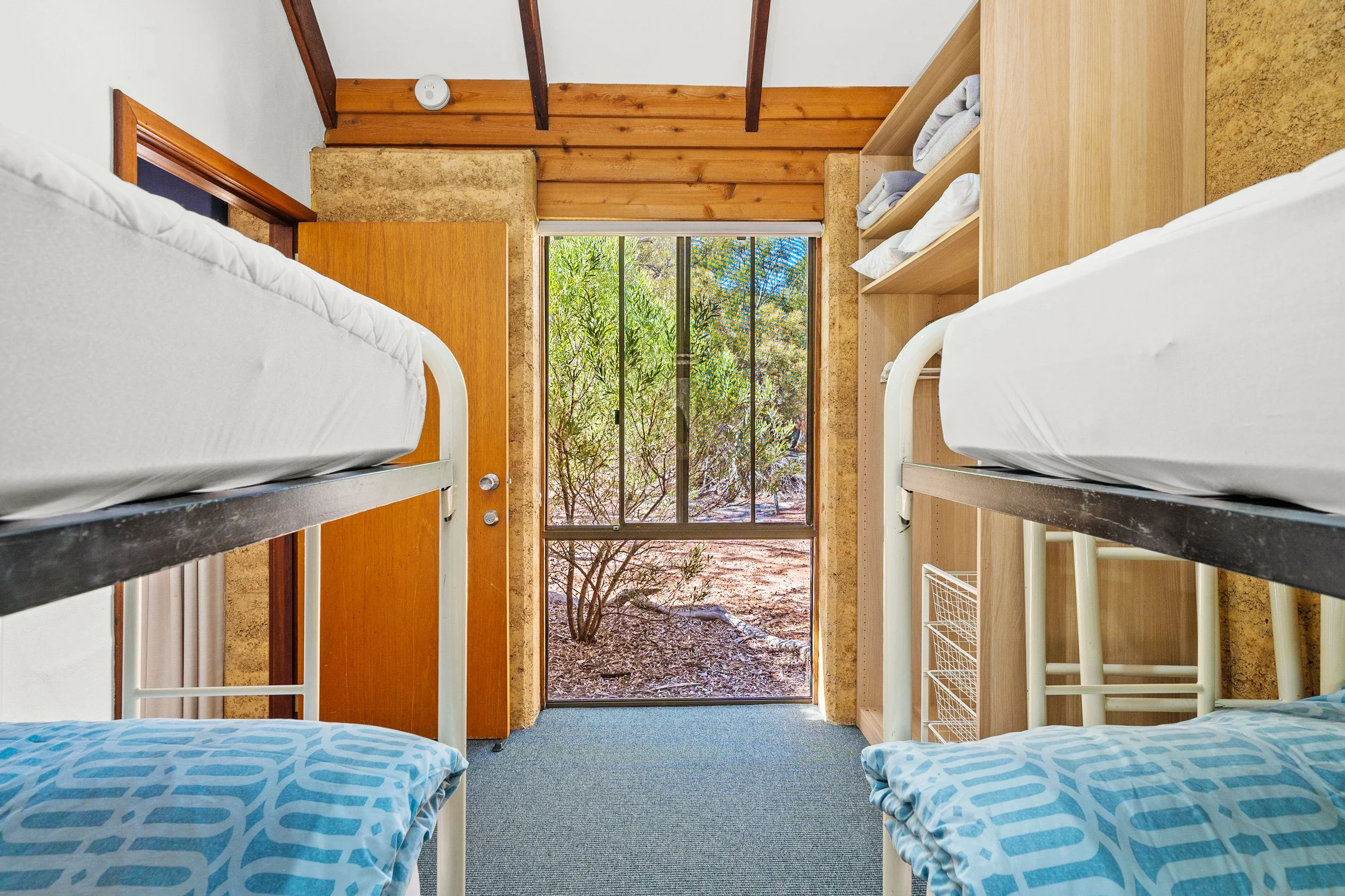 2 twin bunk beds in room with big window overlooking natural Australian bush at Bussells Bushland Cottages in Margaret River