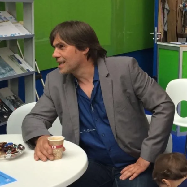 Wilhelm Halmen sitzt im Anzug an einem Messestand von Heprotex.