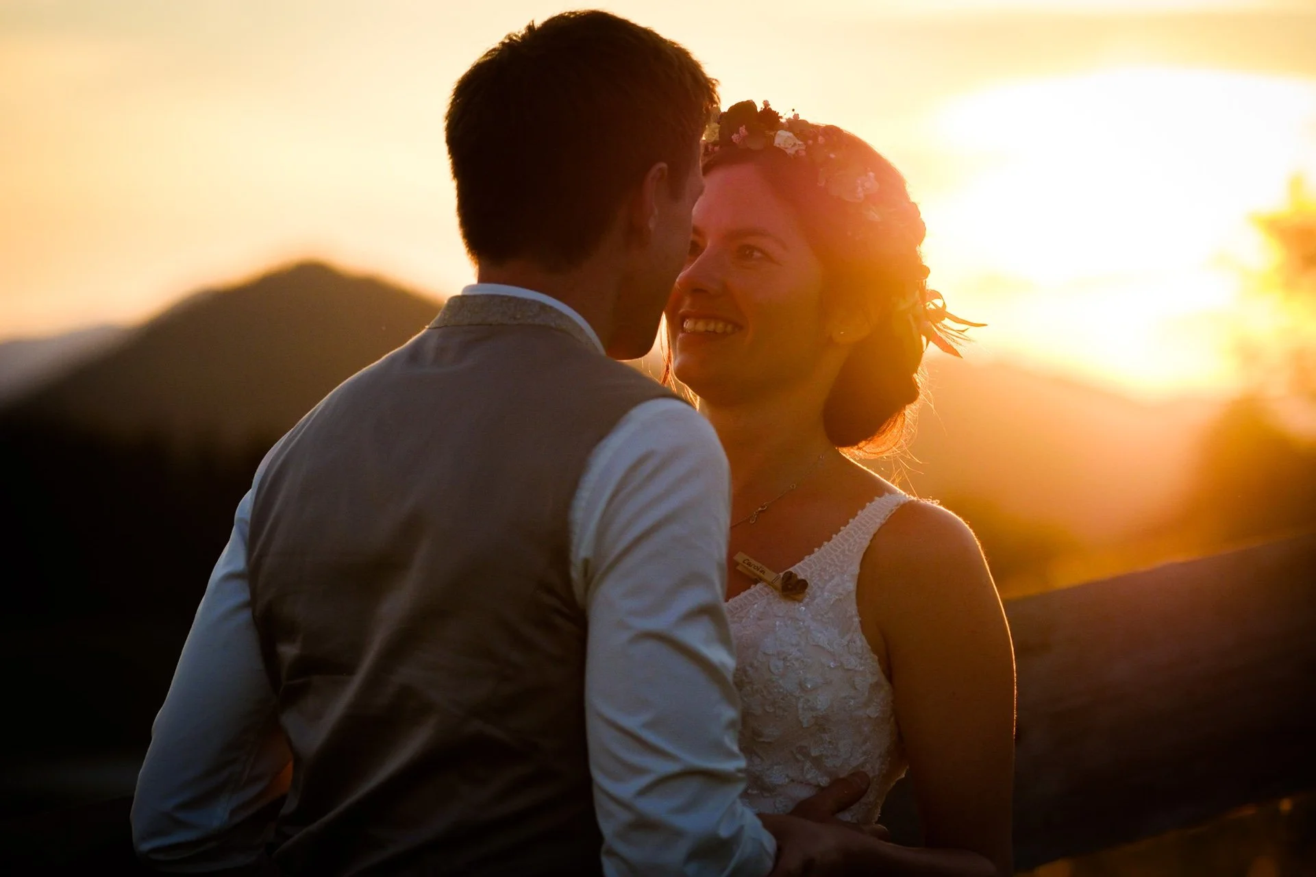 Ein lachendes Paar bei Sonnenuntergang in Bayern, nach einer Hochzeitszeremonie.