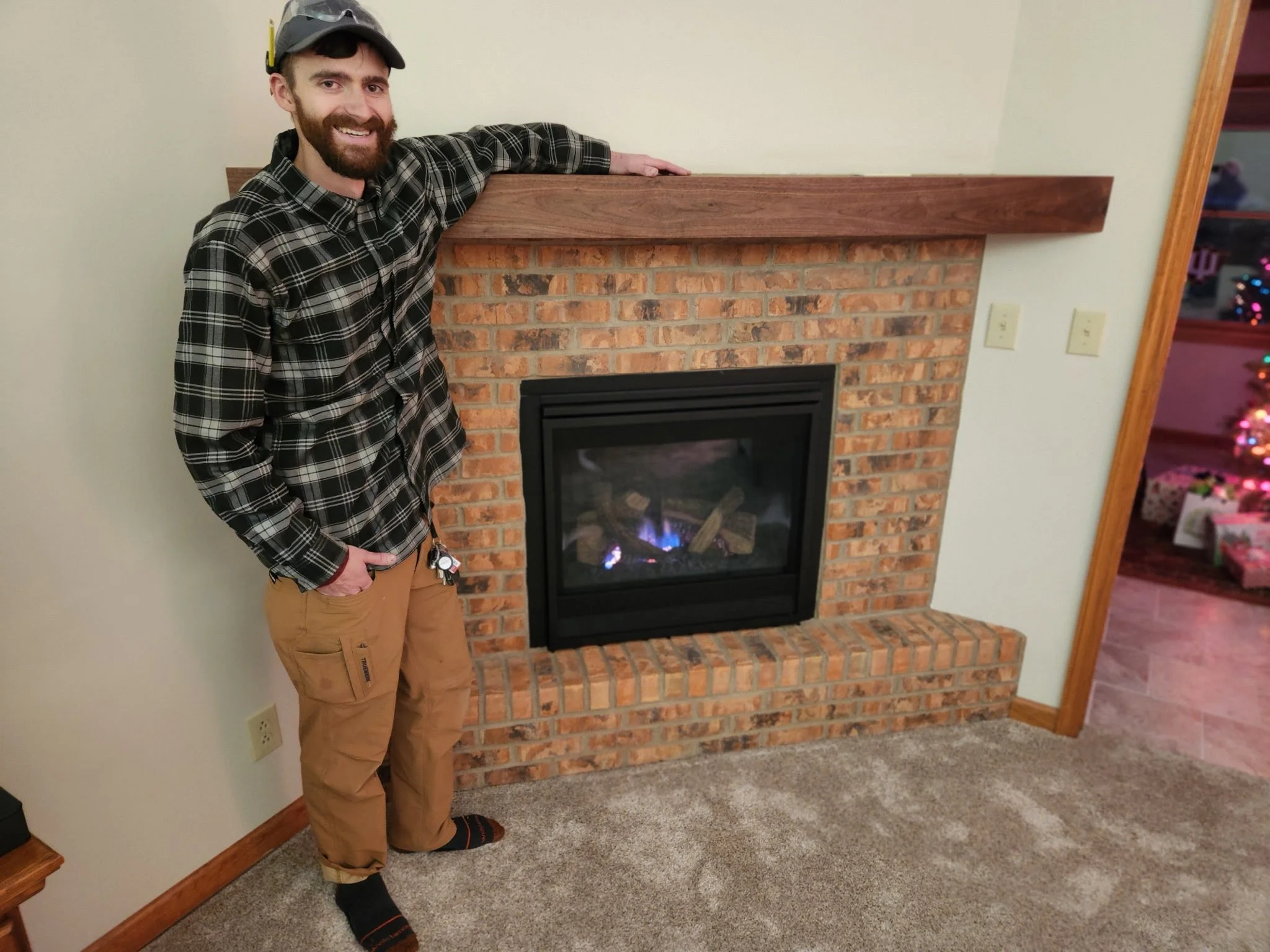 A man with a beard, wearing a black and white checkered shirt, khaki pants, and socks, stands next to a brick fireplace with a wooden mantel, smiling at the camera.


Installed in Centerville Ohio 
