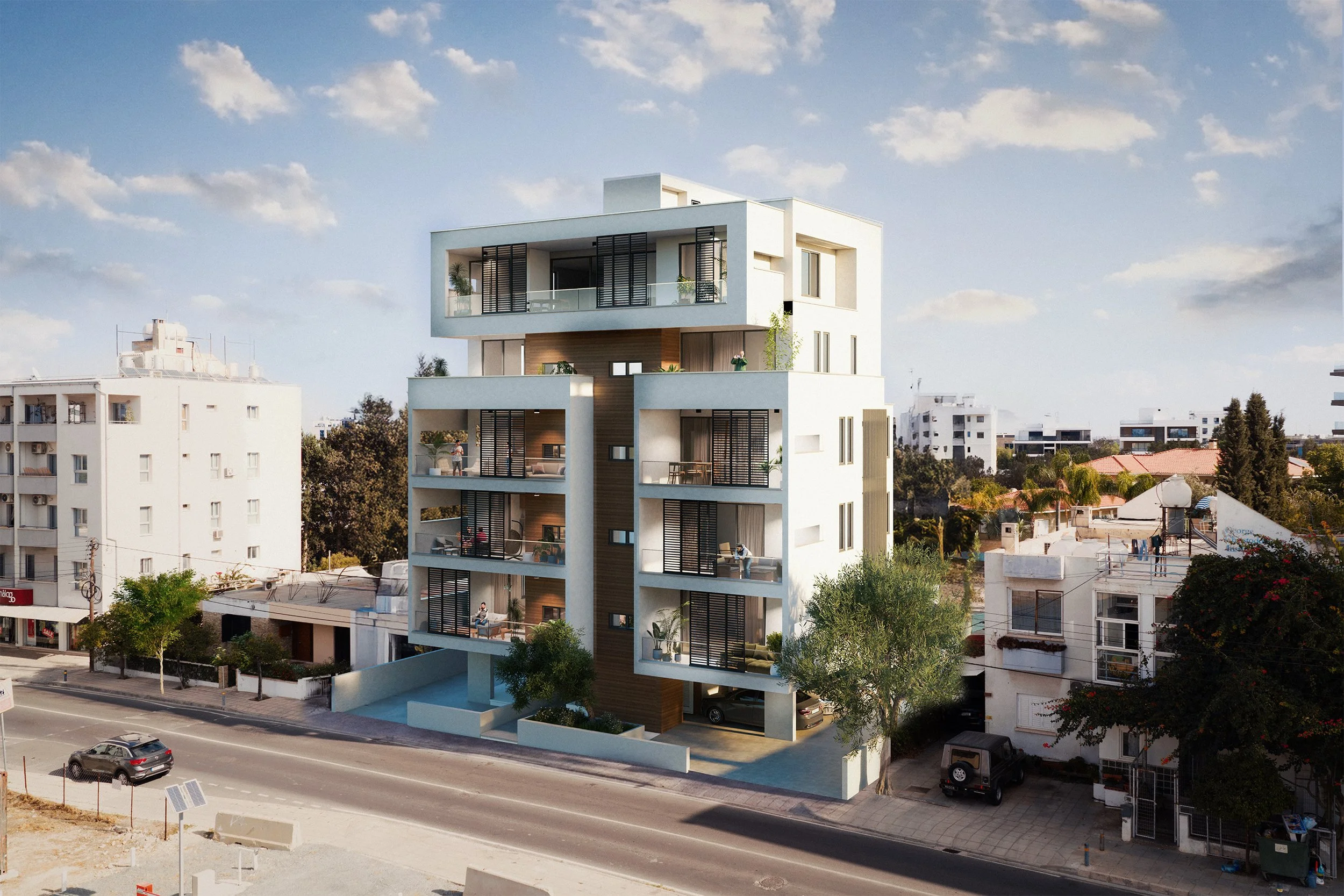 Modern multi-story residential building with balconies and outdoor spaces in an urban area, with several trees and parked cars in front under a partly cloudy sky.