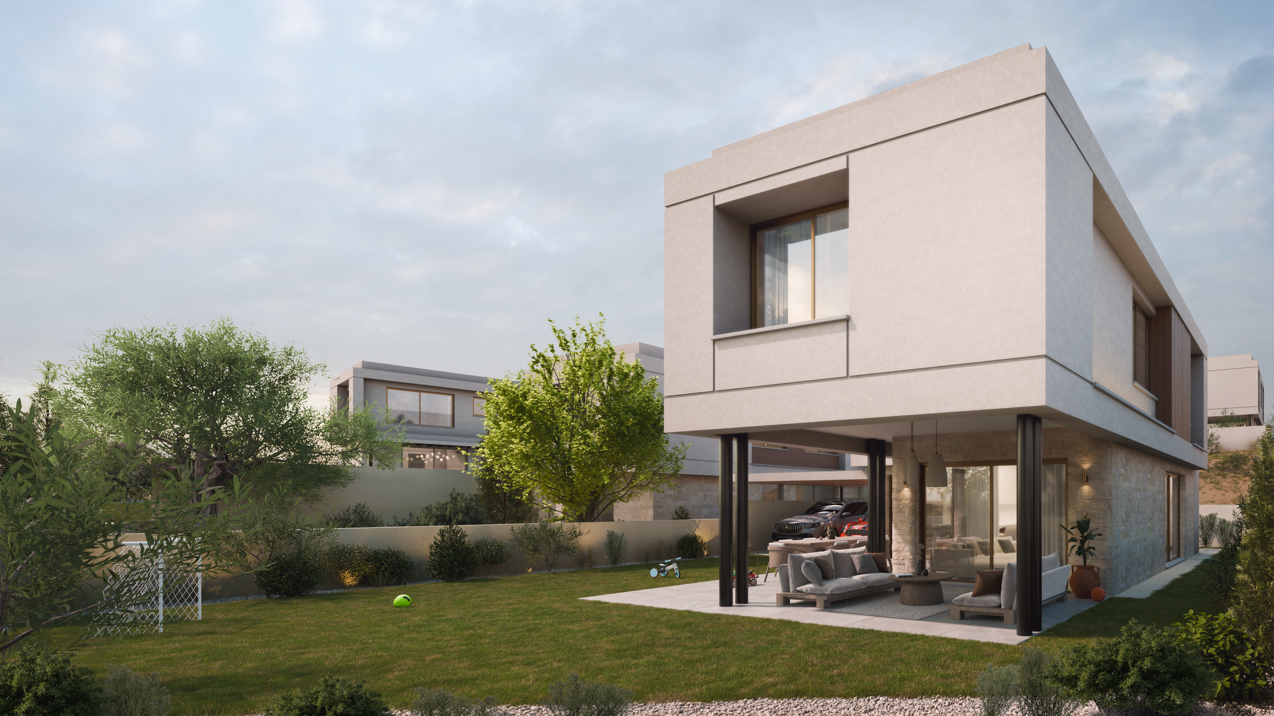 Modern two-story house with large windows and covered patio, surrounded by a landscaped yard with trees, grass, and children's toys.