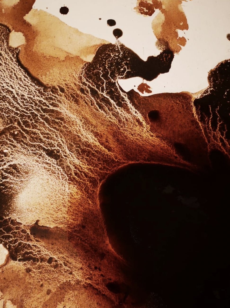 Immagine artistica che rappresenta un paesaggio desertico con formazioni rocciose e un cratere centrale buio, con colori caldi come marrone, arancione e beige.