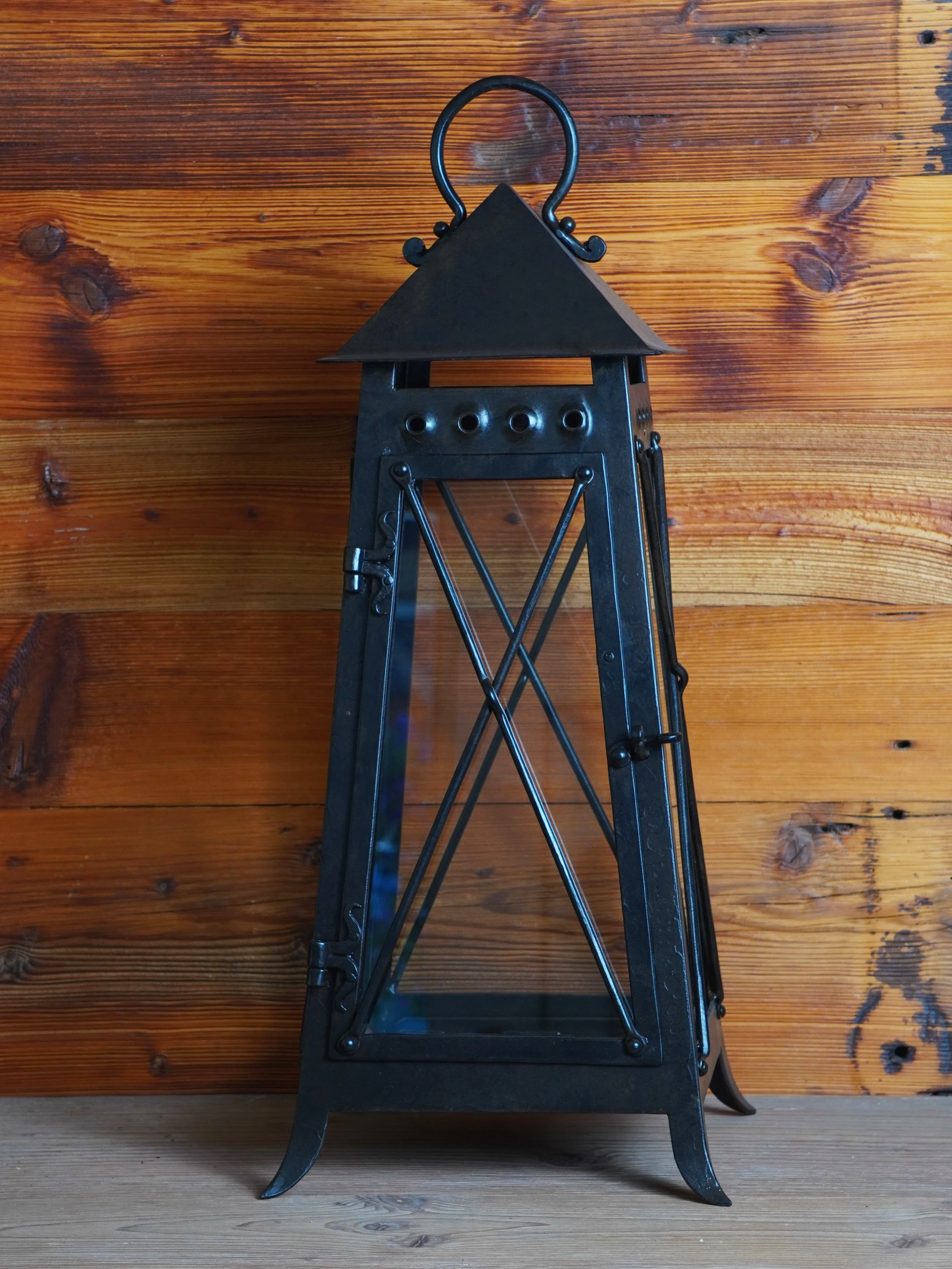 Schwarzer Gartenfackel mit Glasfenster vor holzwand