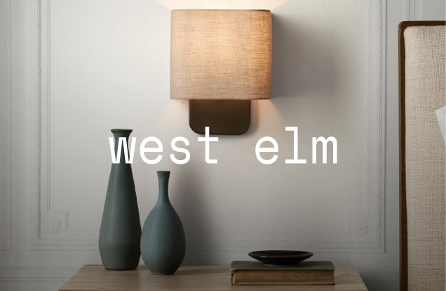 A bedroom wall with a beige wall lamp above a wooden dresser, two tall vases, a bowl, and a stack of books on the dresser, and text reading 'west elm' across the image.