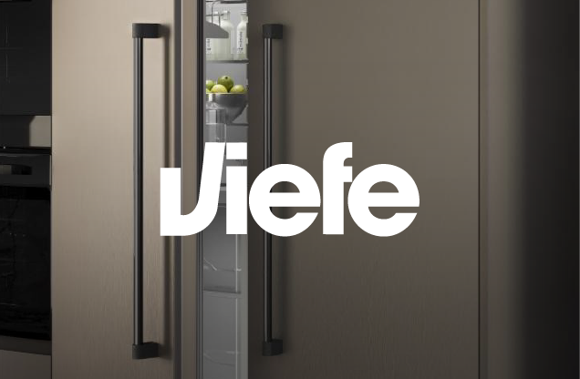 Modern kitchen with a gray refrigerator, an apple bowl inside the fridge, and the word 'jefe' overlayed in large white letters.