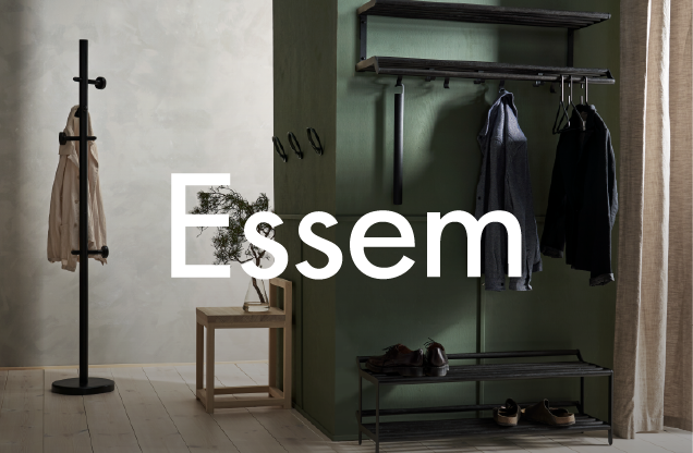 Interior of a modern entryway with a coat rack, small wooden table with a plant, and wall-mounted hooks with hanging coats and shoes, featuring the brand name 'Essem' overlaid.