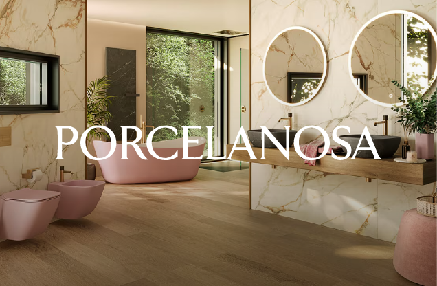 Modern bathroom with pink bathtub and matching bidet, marble walls, large mirrors, a wooden vanity with two sinks, and greenery visible through glass doors.