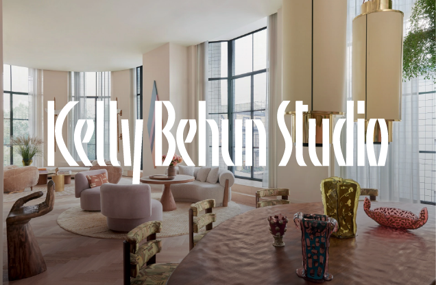 Interior of a modern, stylish room with large windows, round furniture, and colorful decorative objects on a table.