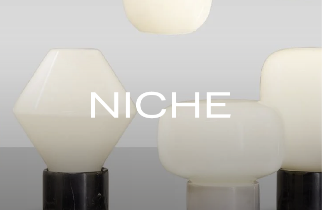 Display of modern ceramic table lamps with black bases and white shades, with the word 'NICHE' overlaid in white text.