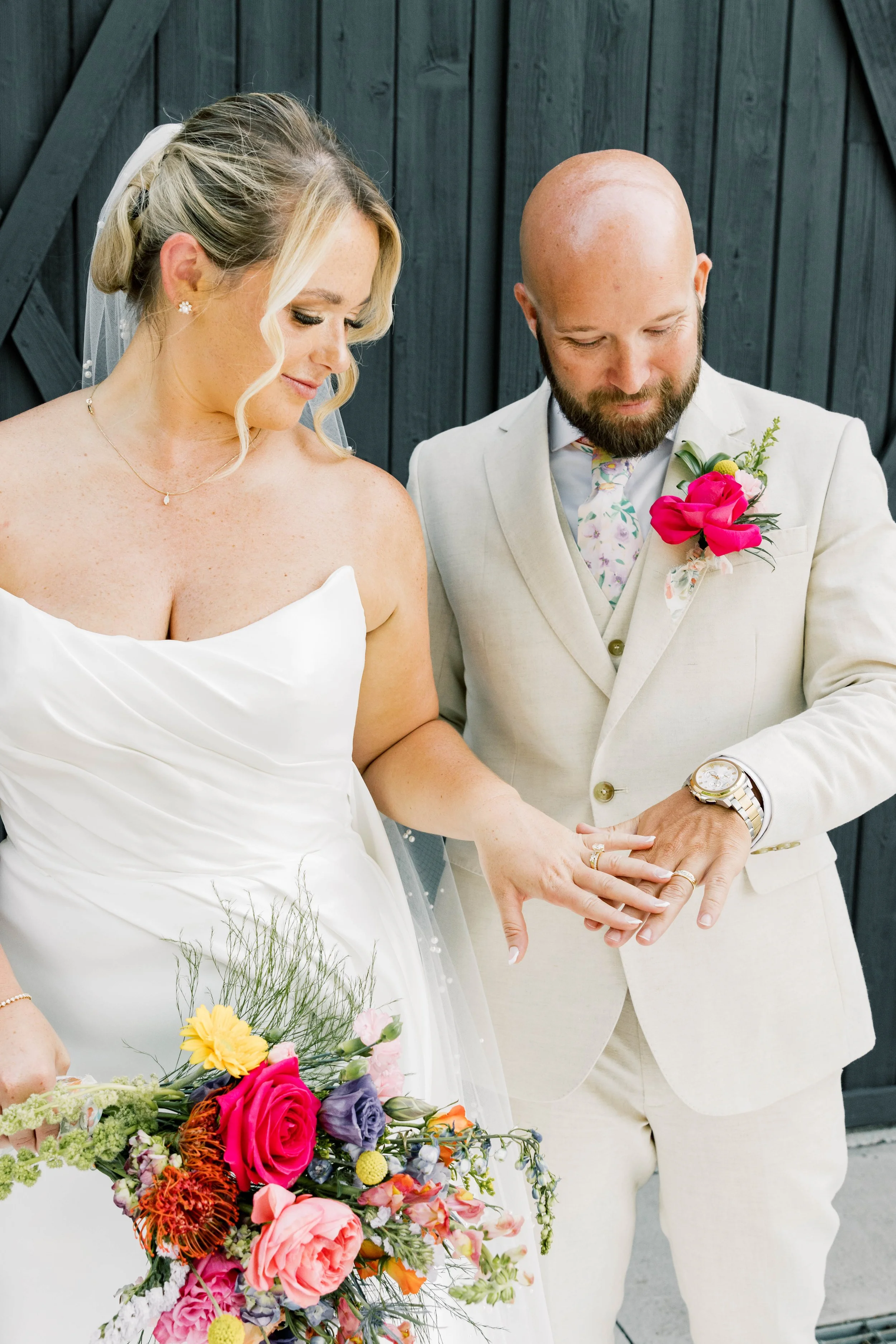Laurie’s customers, Mariana and Carmen holding hands on a green lawn on their wedding day.