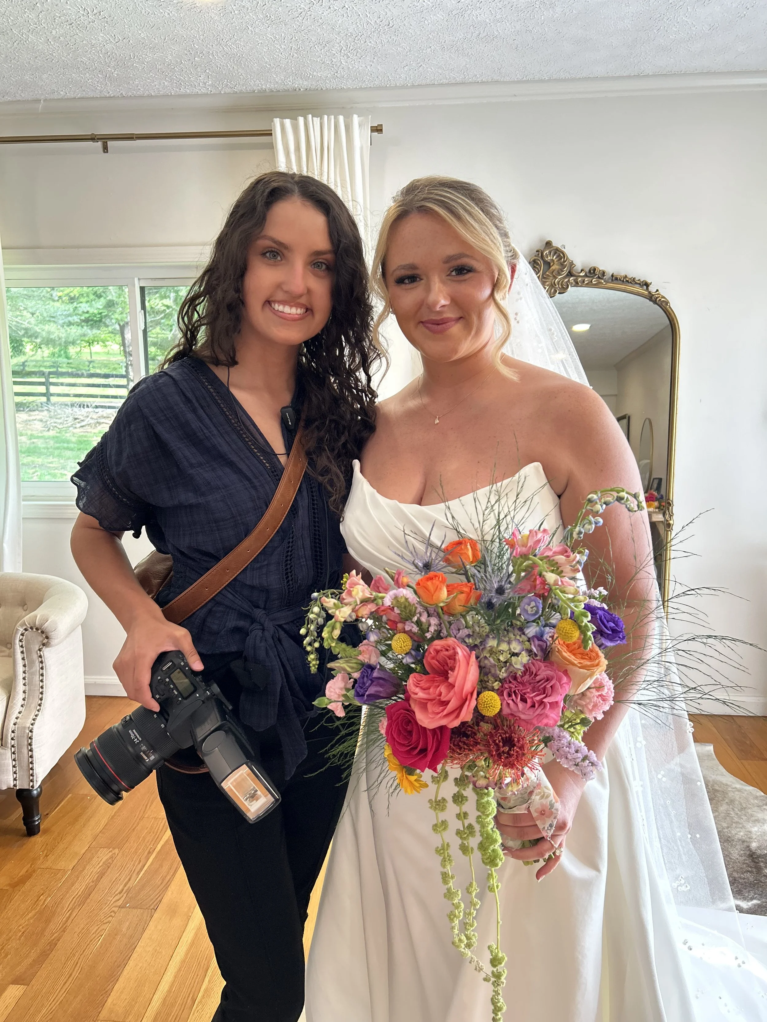 Kenzie, of Kenzie Riley Photography from Kentucky at Red Gate Farm and Vineyard, Quincy, KY taking a photo with a bride before ceremony.