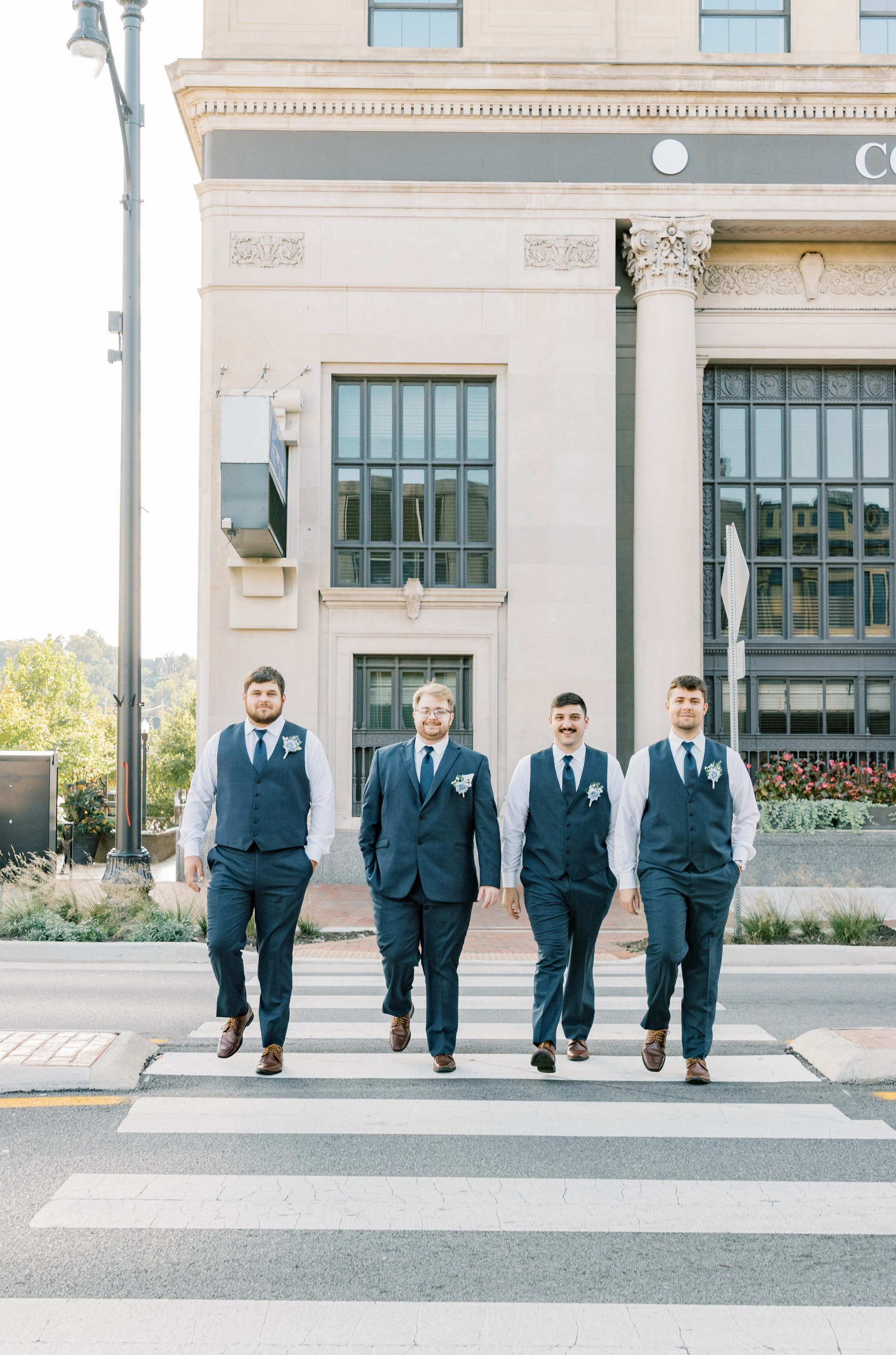 Groomsmen walking across the crosswalk for groomsmen portraits in Ashland, KY by Central Park. Kenzie Riley Photography - Kentucky Wedding Photographer.