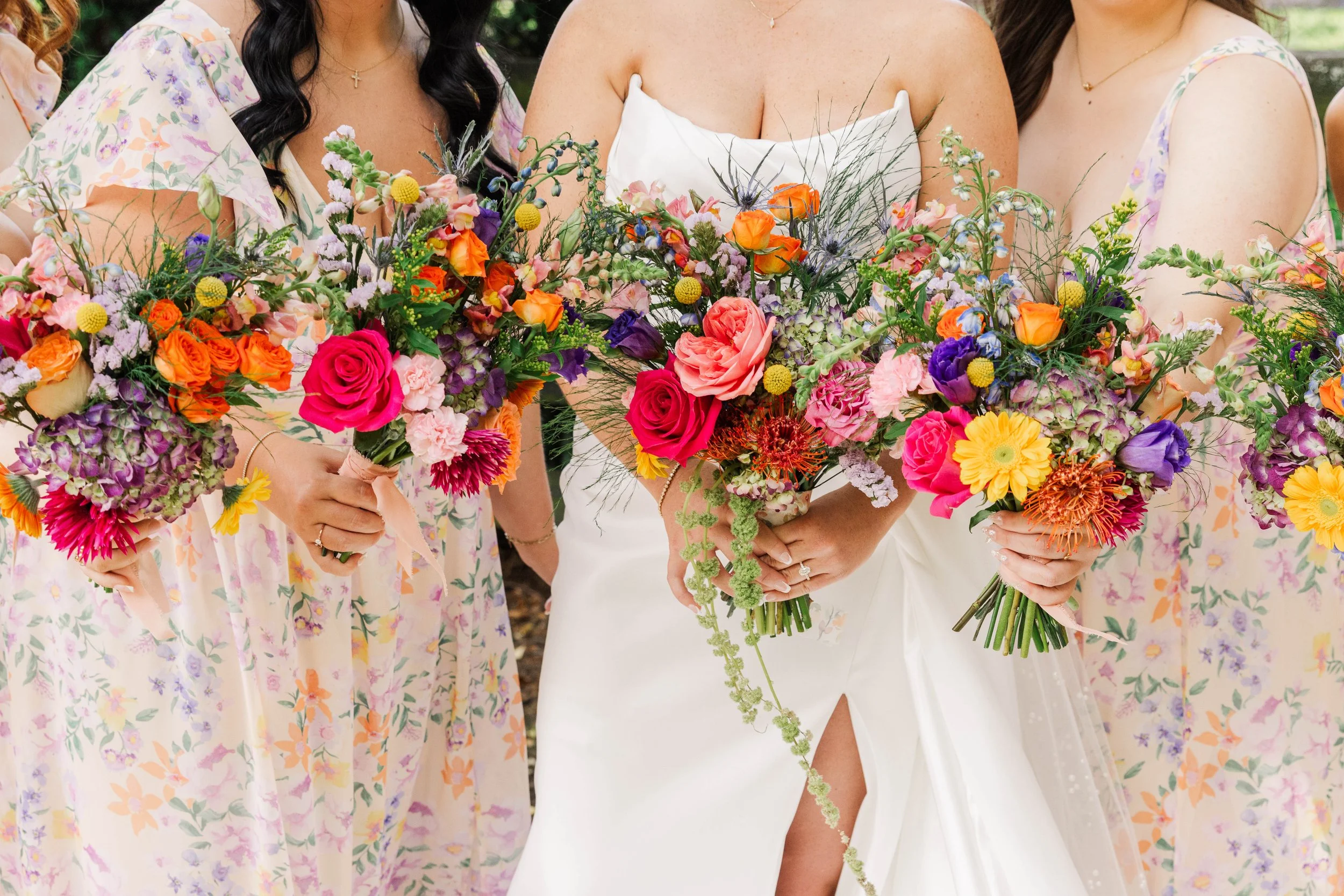 The Carey bridal party holding bright floral bouquets  at Red Gate Farm and Vineyard, Quincy, KY by Kenzie Riley Photography. Kentucky Wedding Photographer.