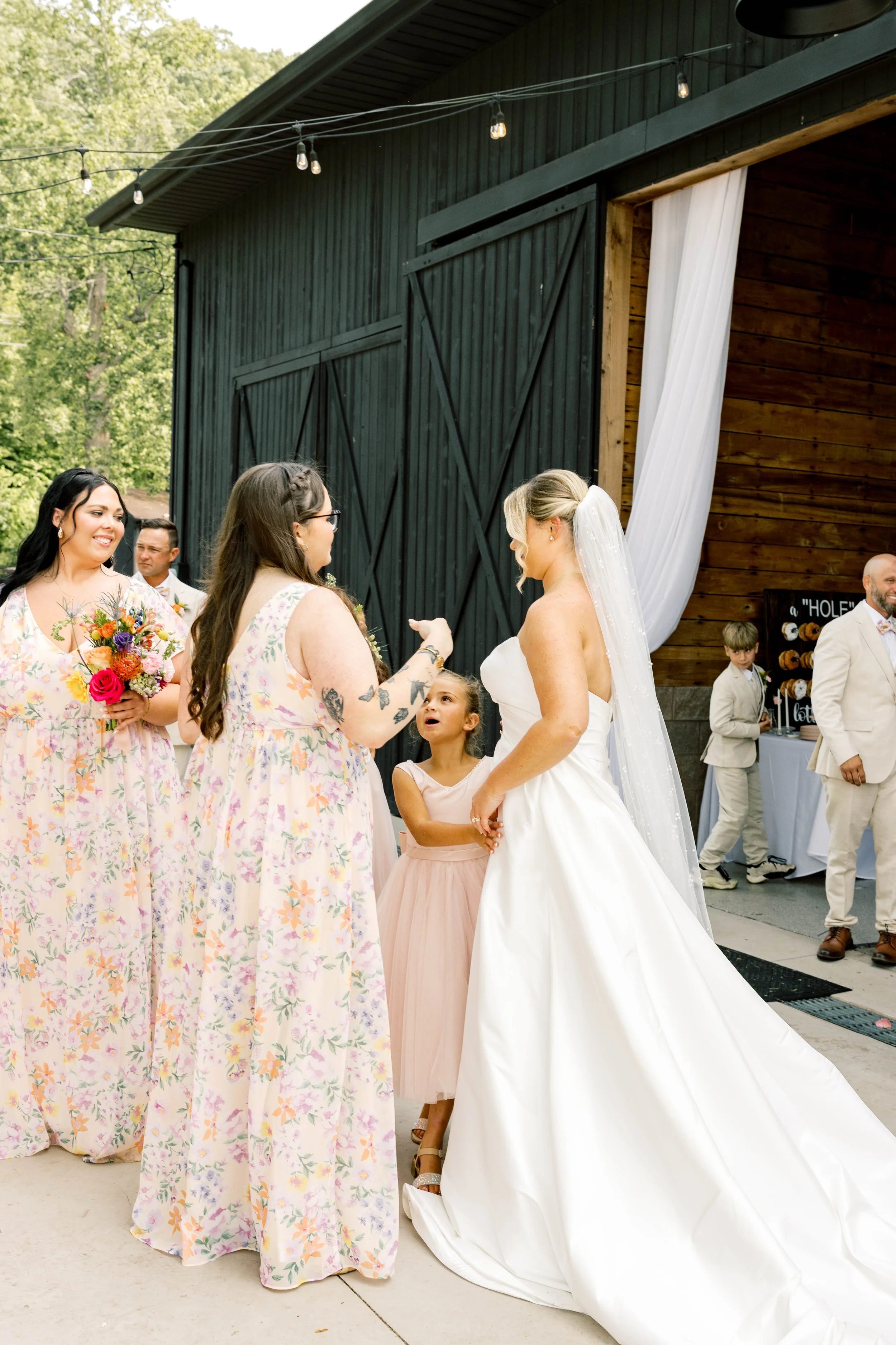 A bride in her dress surrounded by her bridesmaids greeting guests at her reception at Red Gate Farm and Vineyard, Quincy, KY by Kenzie Riley Photography - Kentucky Wedding Photographer.