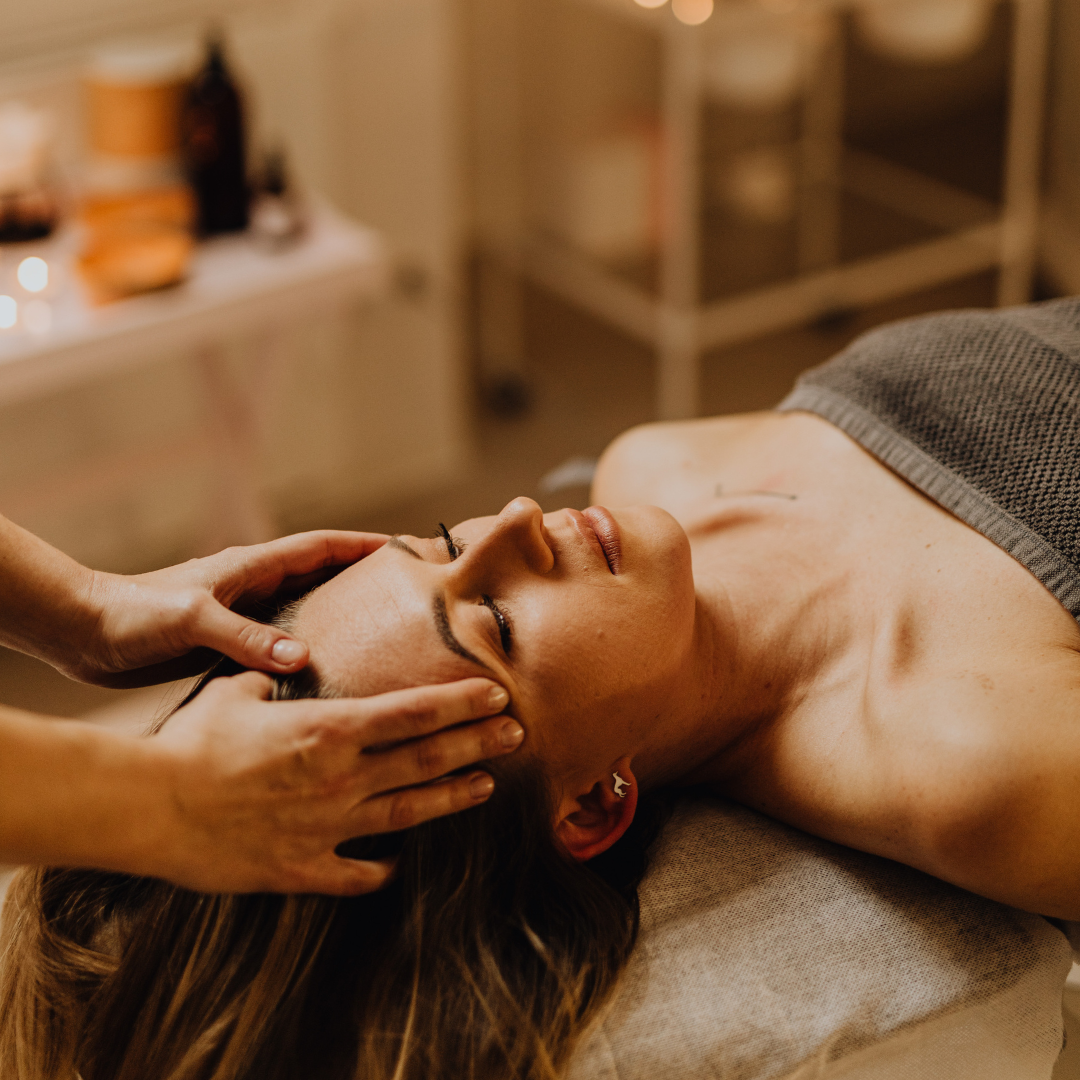 Woman receiving a massage or facial treatment in a spa or salon setting.