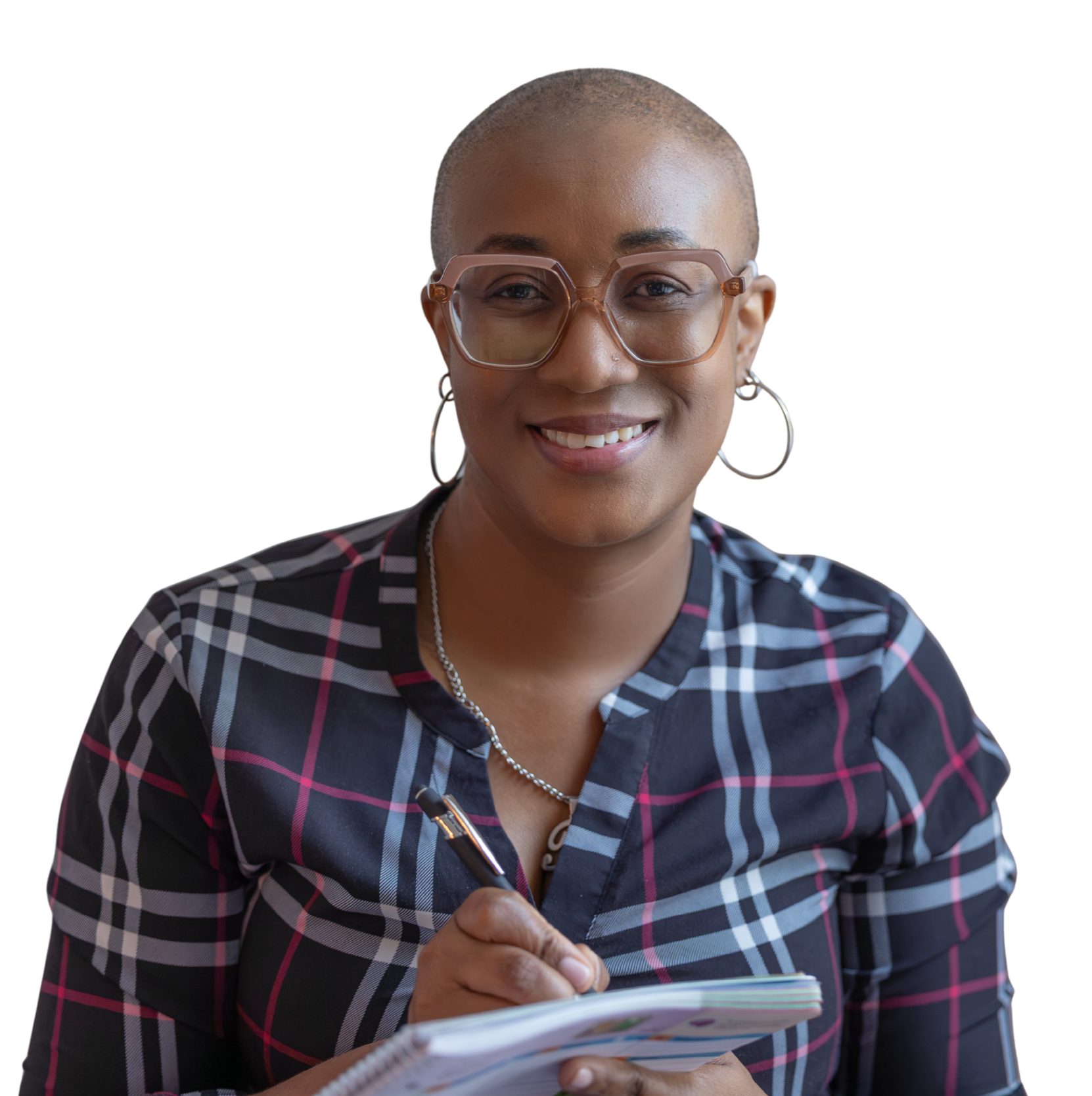 Tamica Daley with a bald head, wearing glasses, hoop earrings, a checkered shirt, and a necklace, smiling and holding a pen and a notepad.
