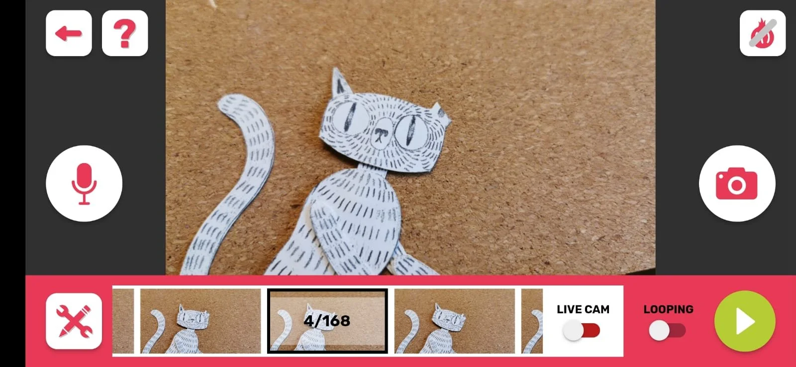 A black and white illustrated paper cutout of a cat on a brown surface
