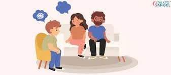 A therapist sitting on a white sofa talking to a young girl and her parents during a counseling session.