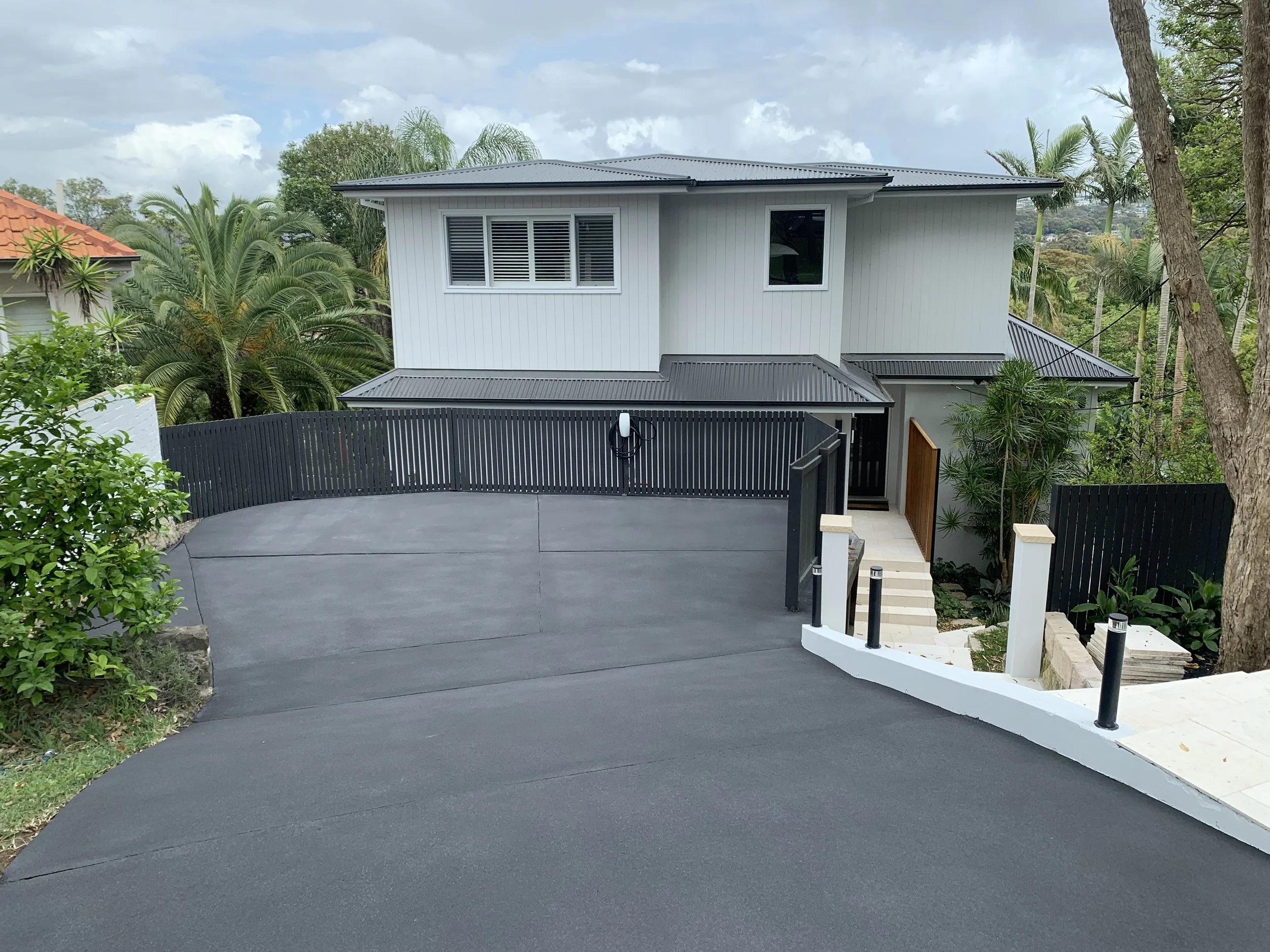 The Result: Following industrial-grade 4000+ PSI pressure blasting, we restored the grip and aesthetics with a bold, charcoal resurfacing coat. The dark finish provides a stunning, high-contrast look against the white modern architecture.