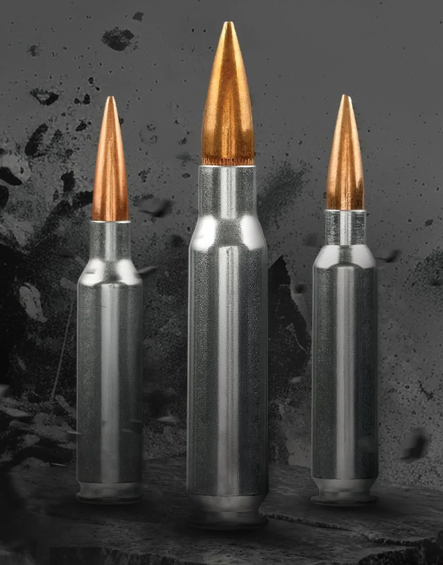 Three rifle bullets with copper tips and metallic casings are standing upright on a dark, textured background.