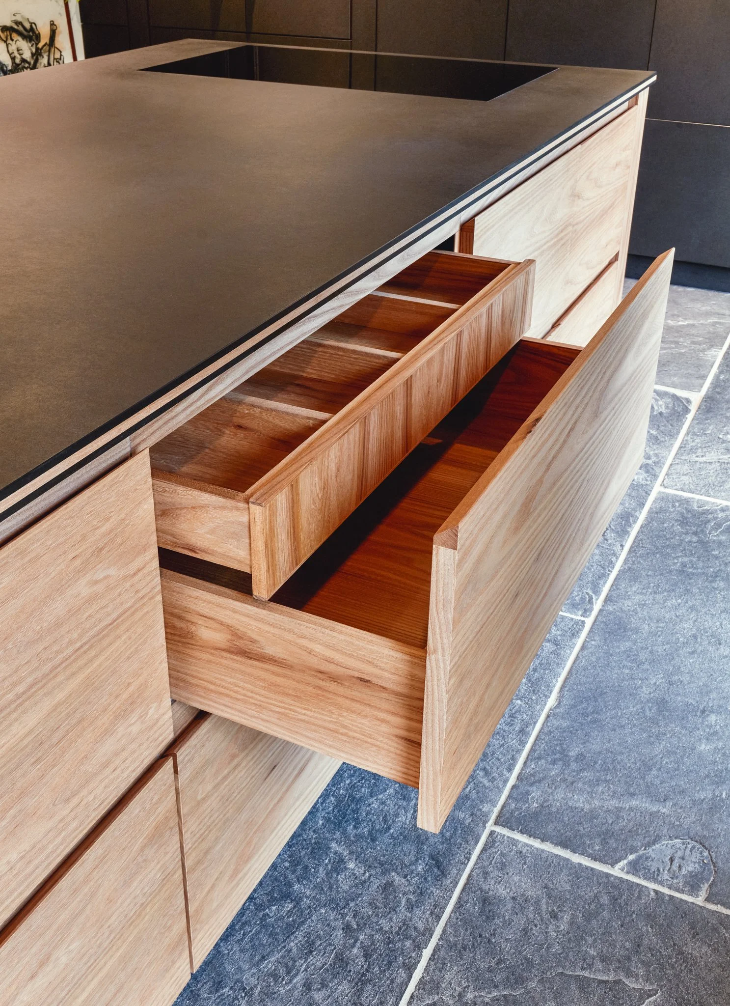 Bespoke elm kitchen with quality worktops and warm timber joinery in a Devon stone barn, Slapton