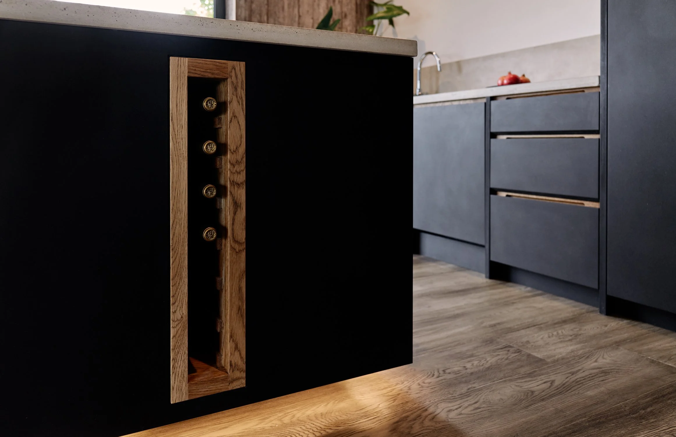 Bespoke dark black kitchen cabinetry with oak handles and hand-cast concrete worktops in Dartmouth, Devon