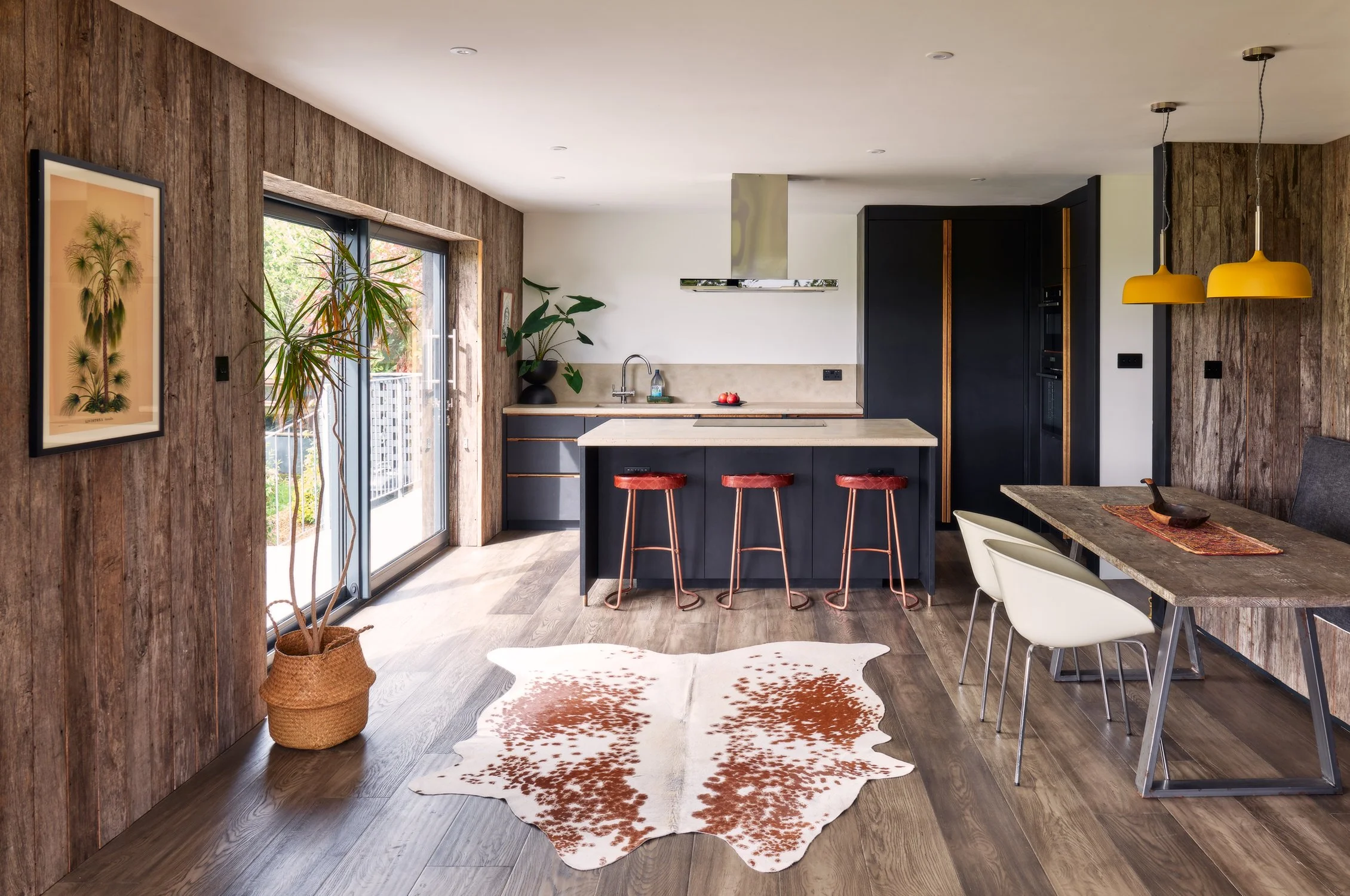 Bespoke dark black kitchen cabinetry with oak handles and hand-cast concrete worktops in Dartmouth, Devon
