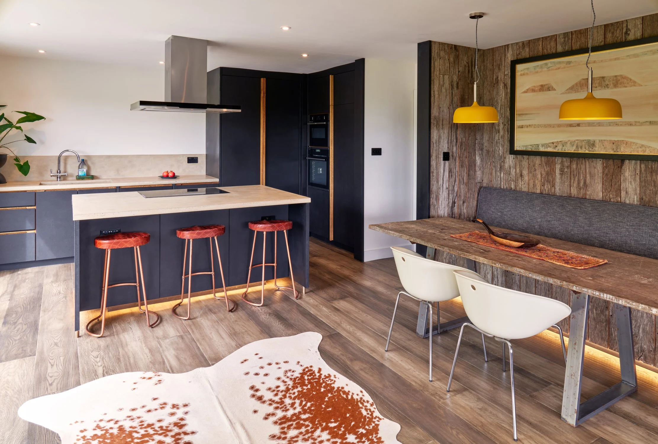 Bespoke dark black kitchen cabinetry with oak handles and hand-cast concrete worktops in Dartmouth, Devon