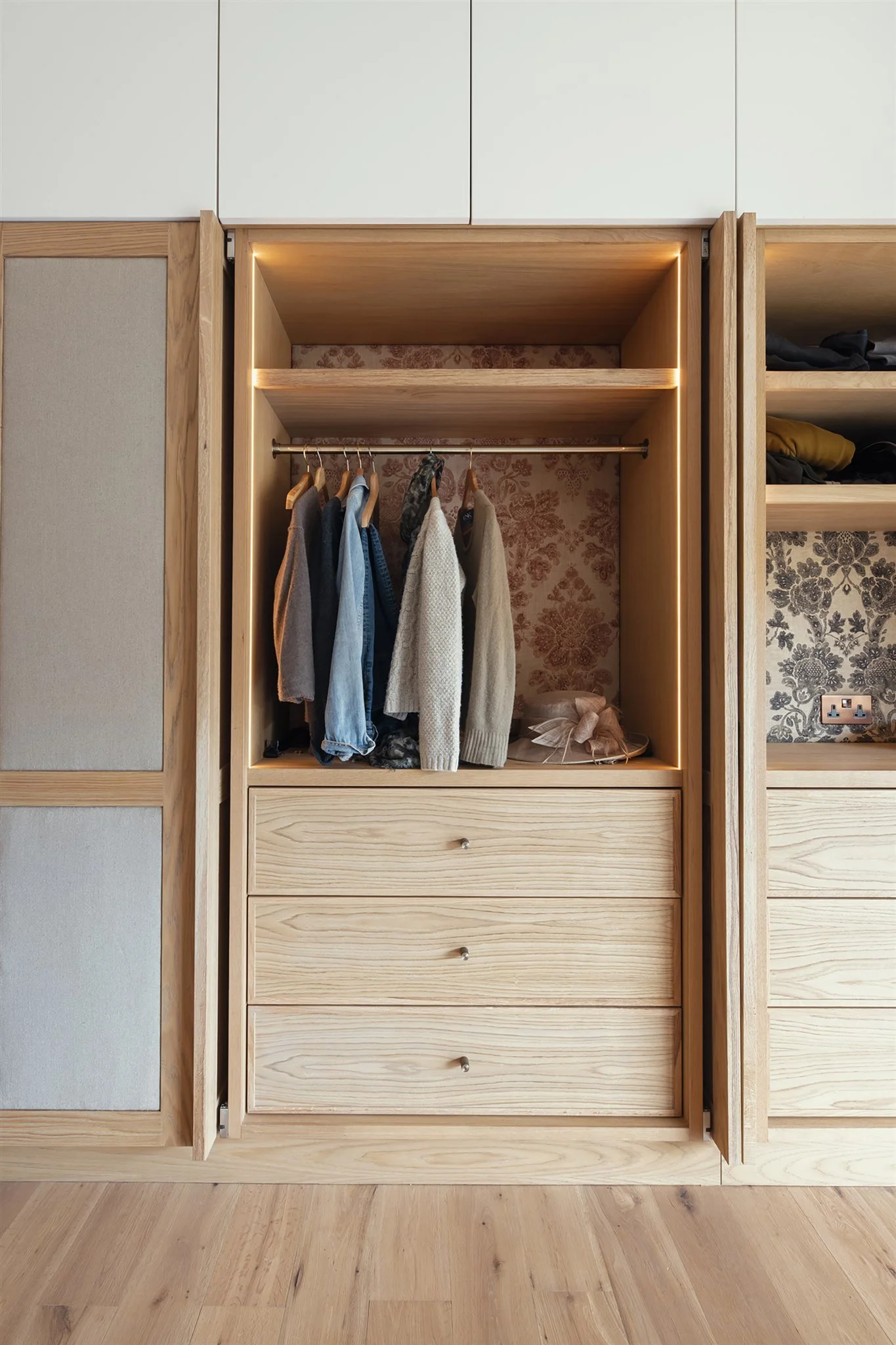 Luxury bespoke master dressing room wardrobes with pivot pocket doors and oak veneer in Dartmouth, Devon
