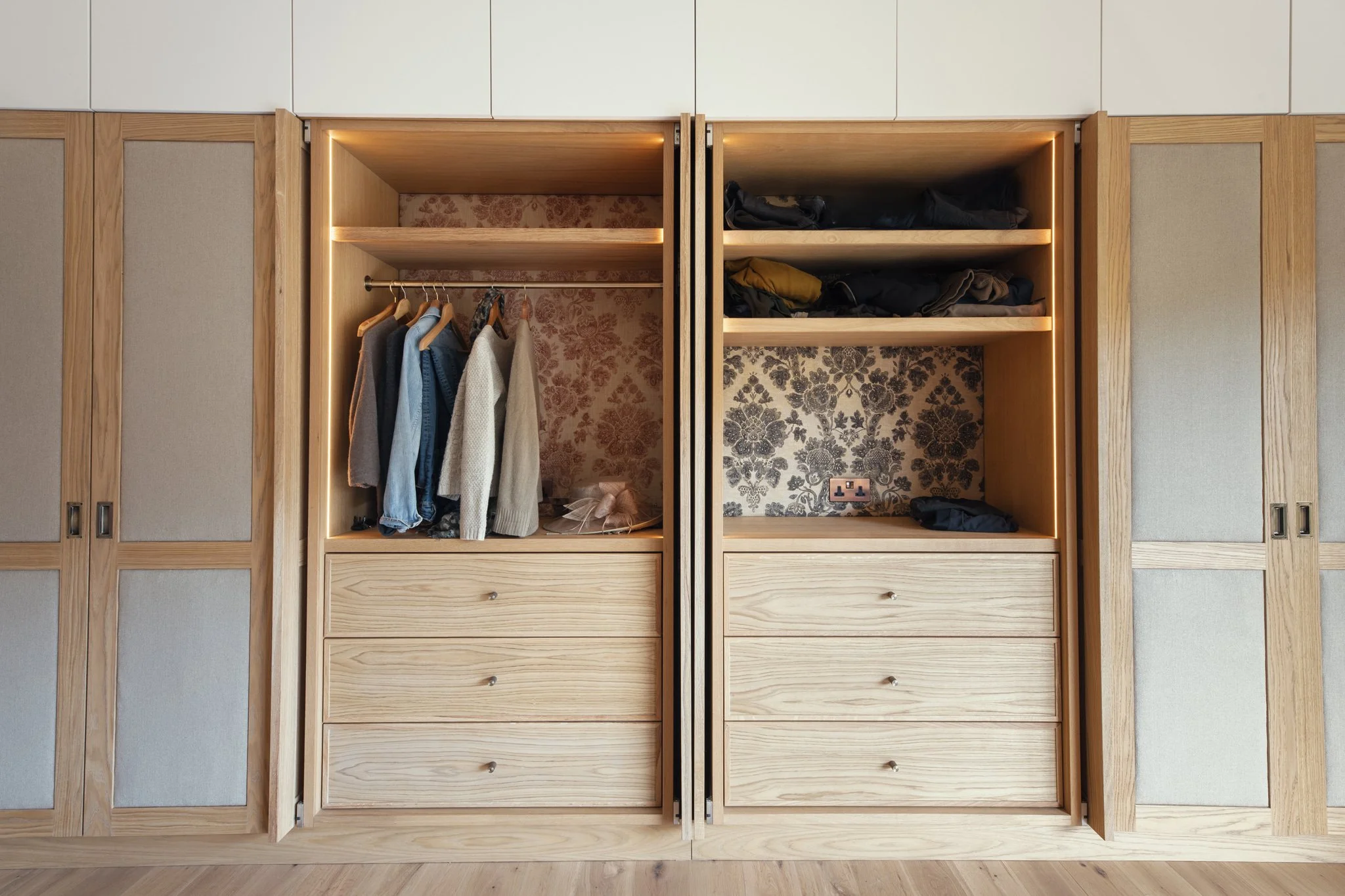 Luxury bespoke master dressing room wardrobes with pivot pocket doors and oak veneer in Dartmouth, Devon