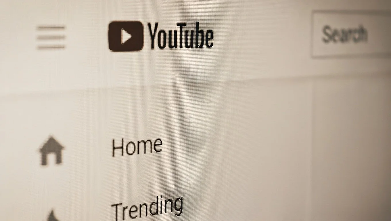 A computer screen displaying the YouTube homepage with navigation options including Home and Trending, and the search bar visible.